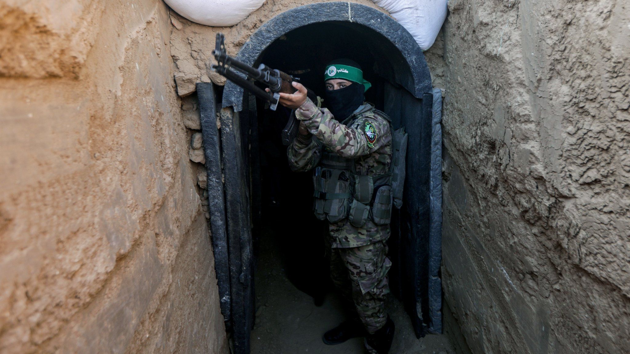 A fighter from Hamas's military wing, the Izzedine al-Qassam Brigades, stands in front of a tunnel in the Maghazi camp, in central Gaza (19 Jul 2023)