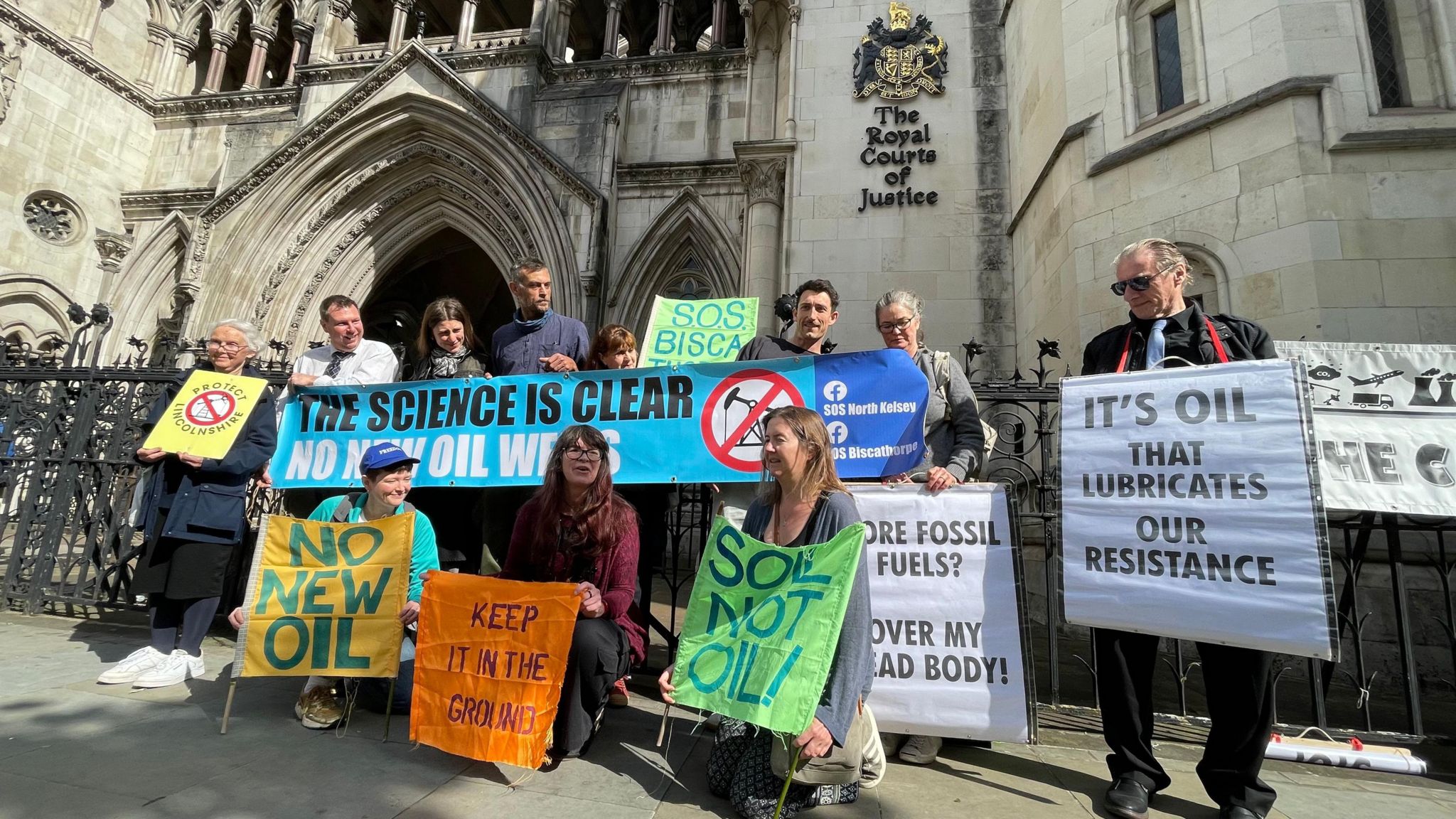 Campaigners from SOS Biscathorpe pose with placards outside the Royal Court of Justice