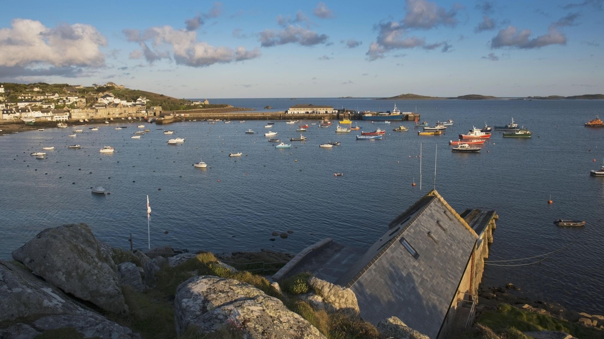 Looking towards the protected harbour on St Mary's island which has many moored boats and houses are visible on the seafront