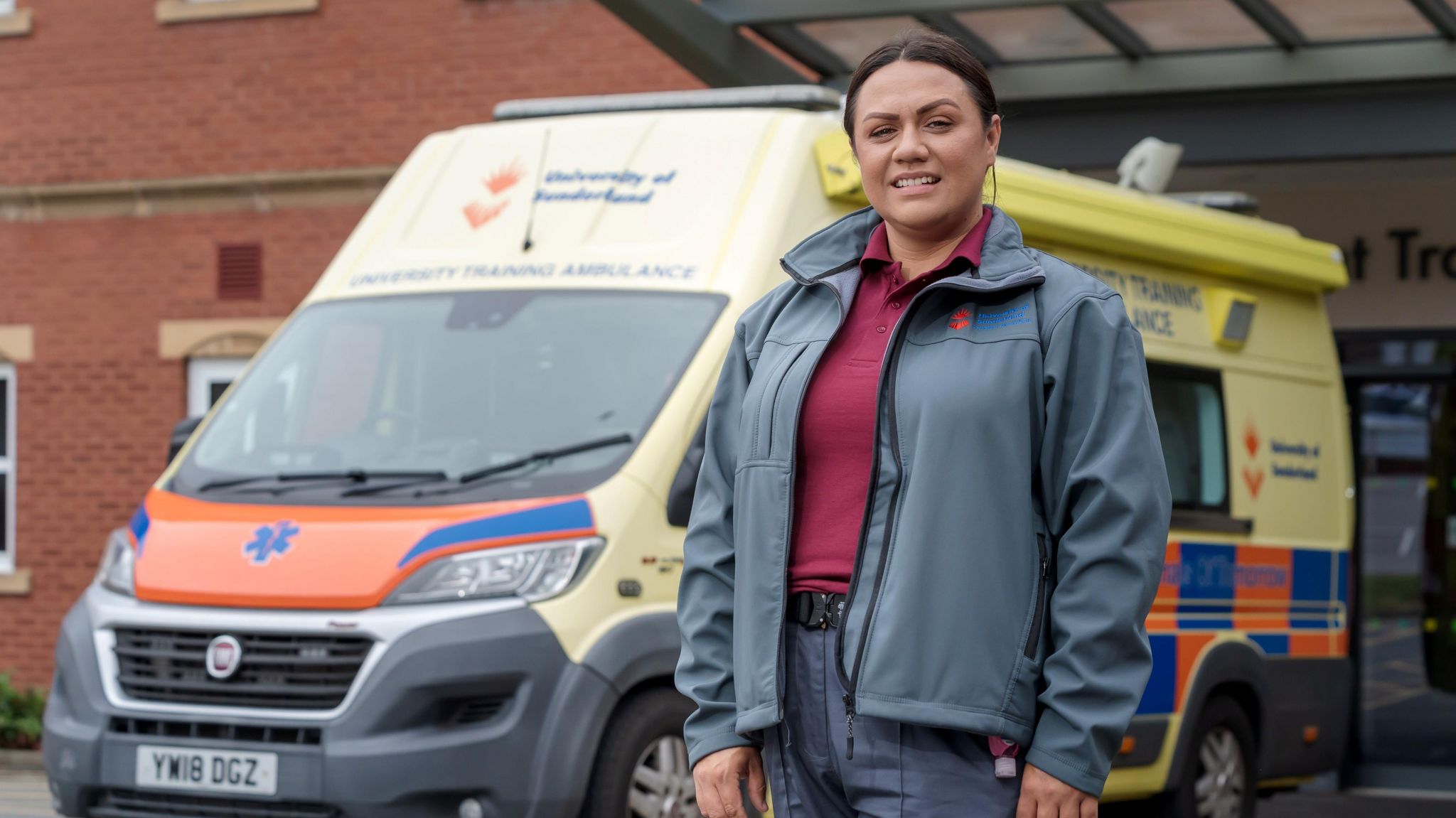 Stacey Thain posing in front of an ambulance