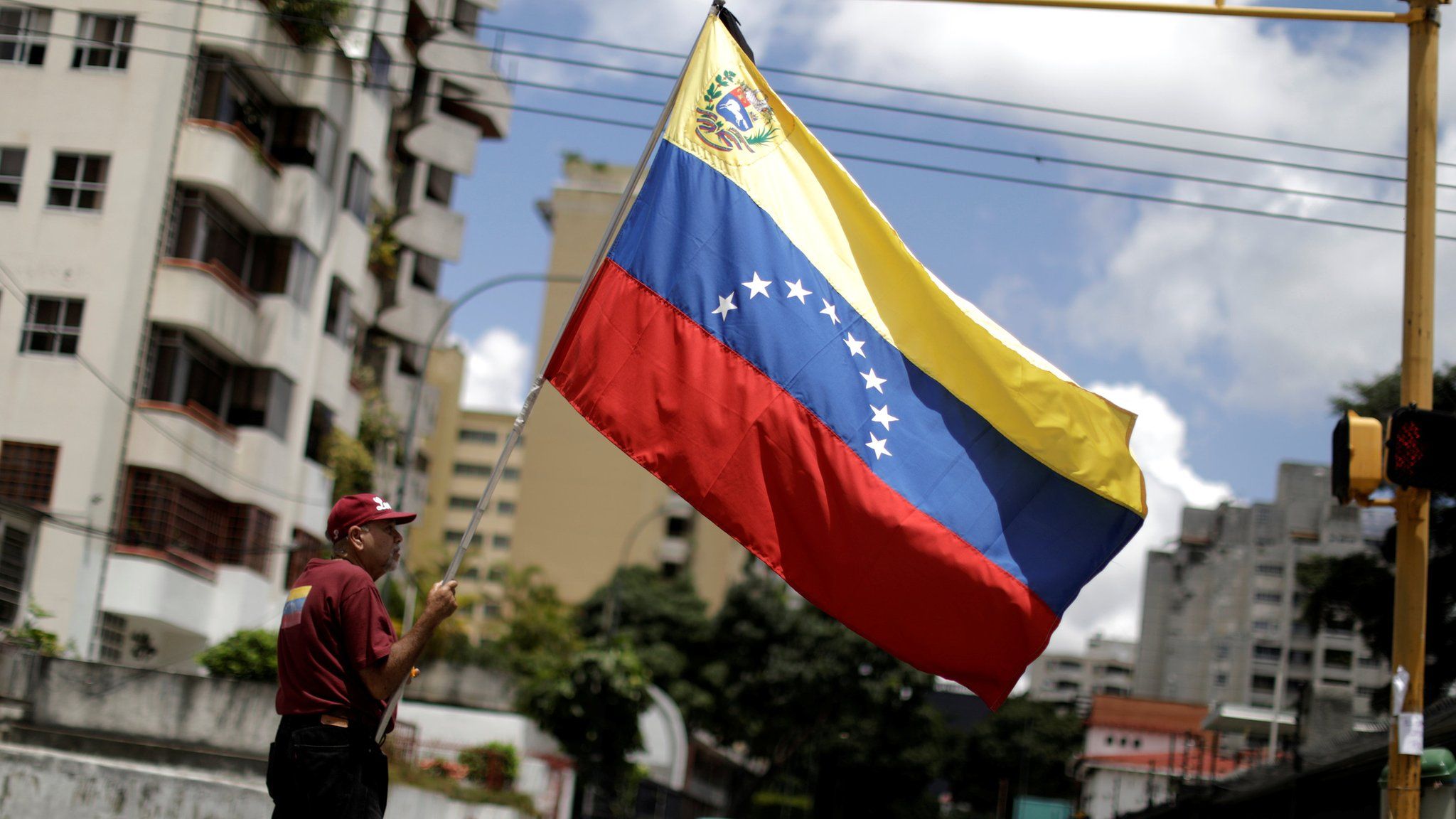 A man with a Venezuelan flag stands in a street after a strike called to protest against Venezuelan President Nicolas Maduro's government in Caracas, Venezuela, July 29, 2017