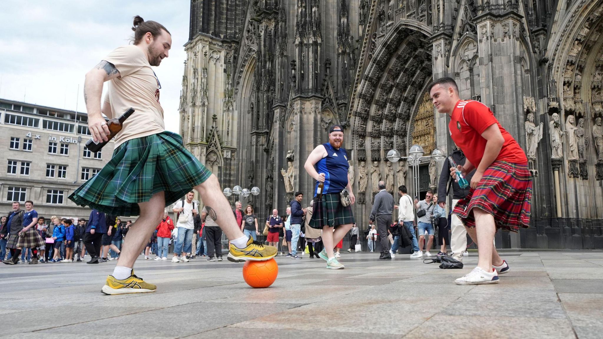 Scotland fans playing football in front of Cologne Cathedral