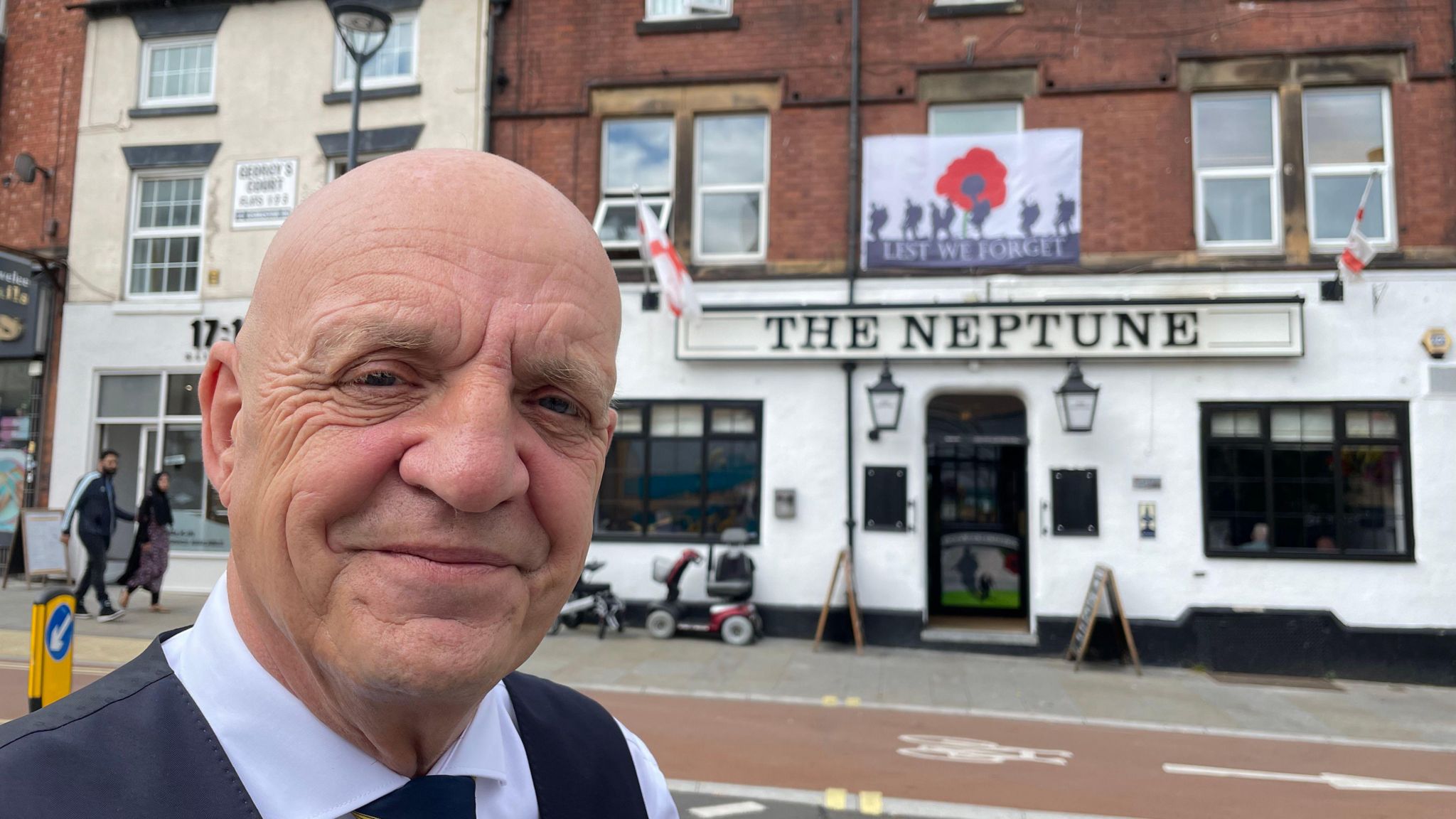 Landlord standing in front of his pub