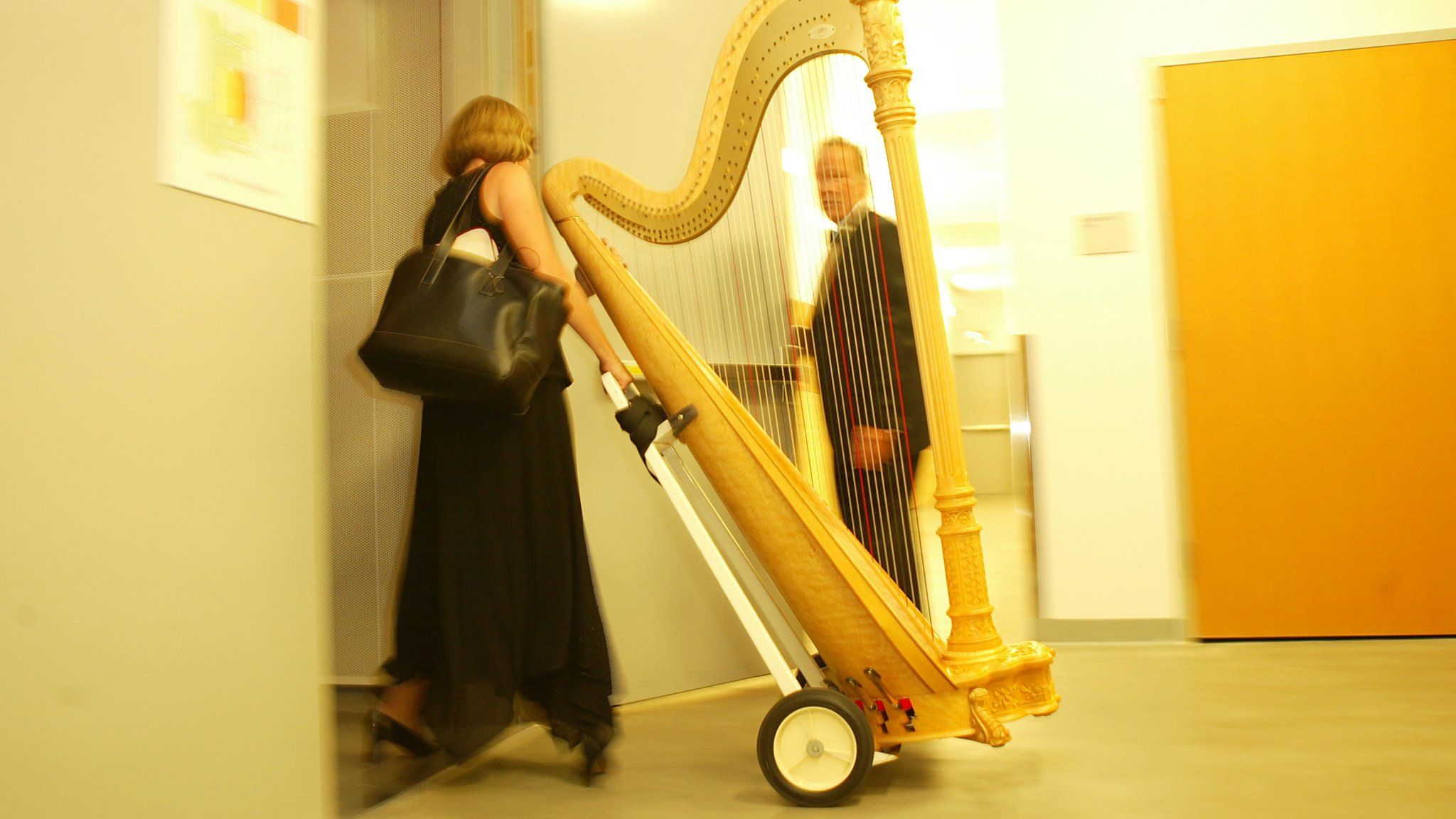 A woman carrying a harp