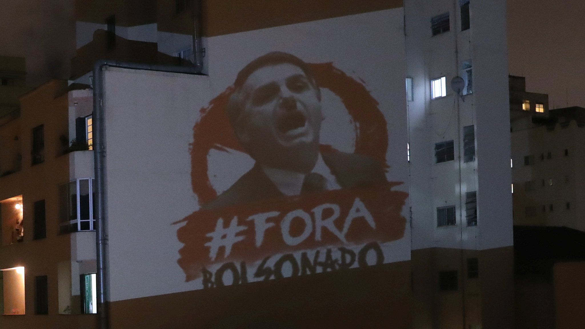 An image depicting Brazil's President Jair Bolsonaro and the phrase "Out Bolsonaro" projected onto a building in Sao Paulo (25 March 2020)