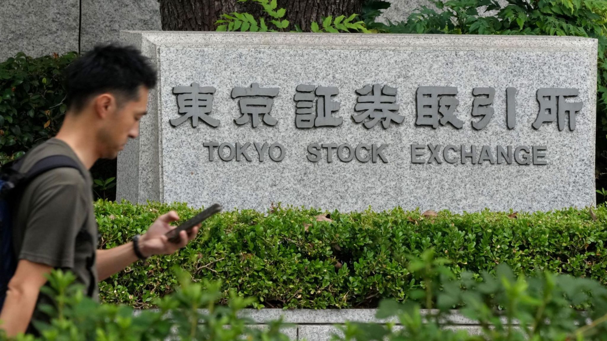 Person walks past Tokyo Stock Exchange.