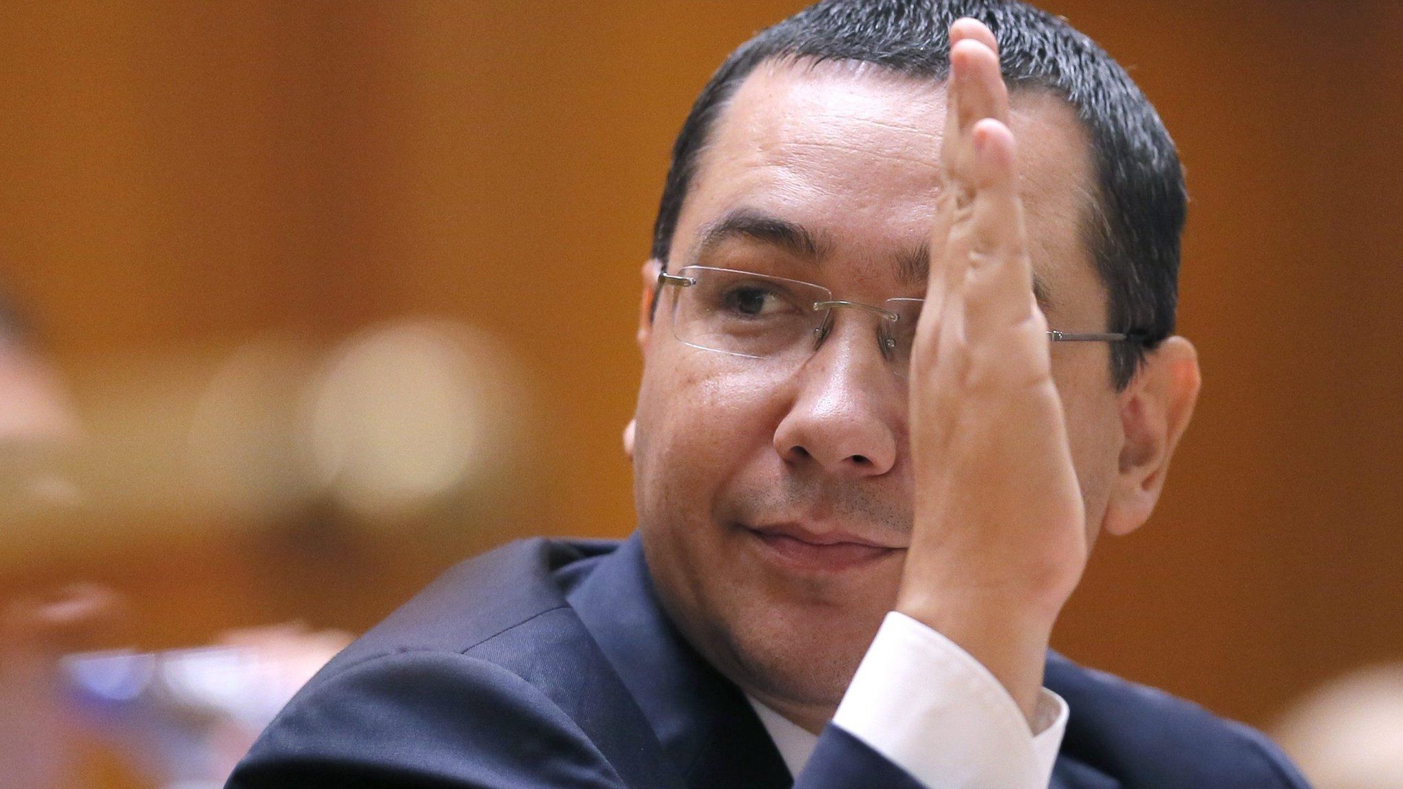 Romanian Prime Minister Victor Ponta raises his hand during a speech in front of both parliament chambers during no-confidence motion procedures