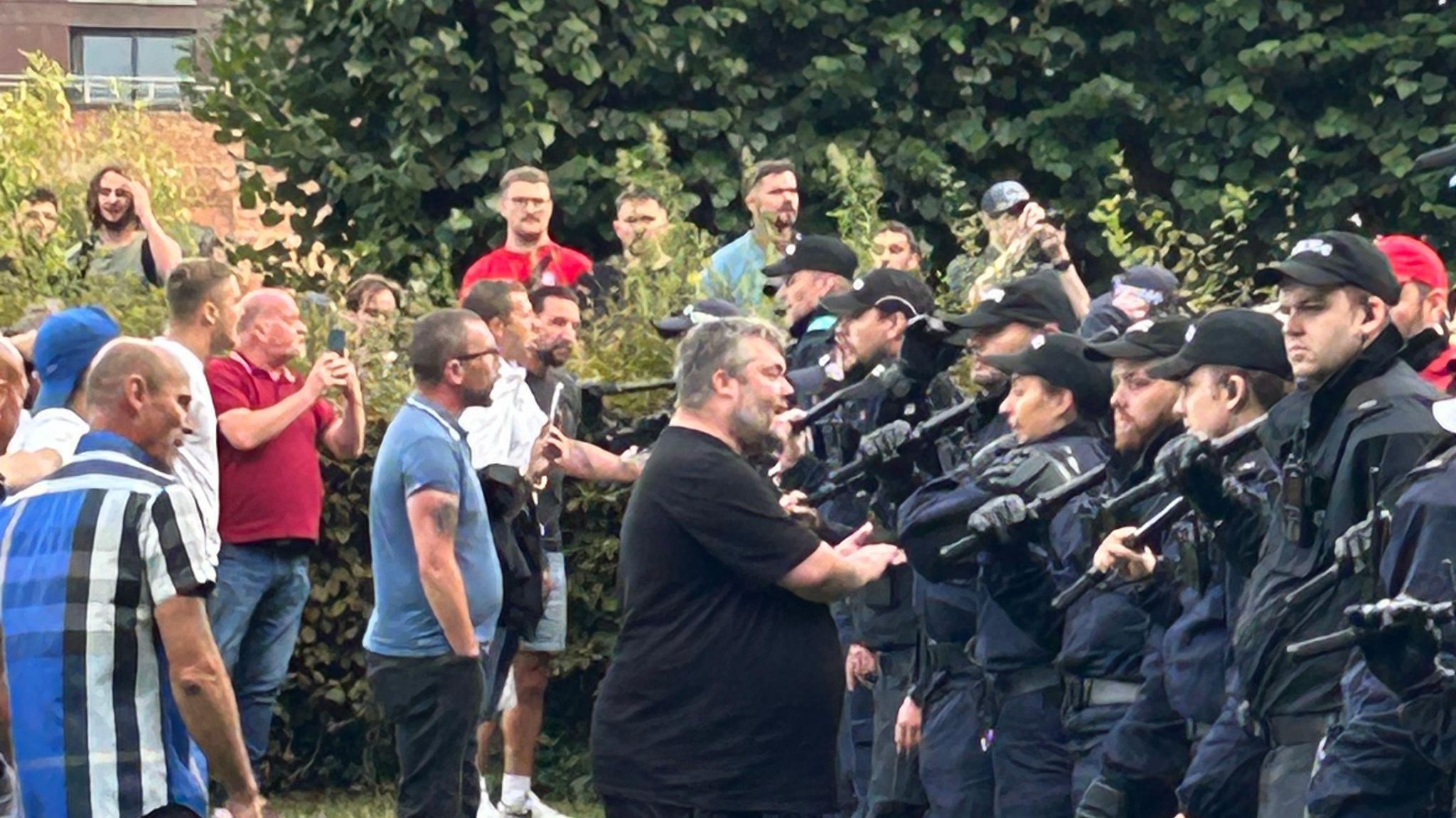 Men stood in front of wall of officers