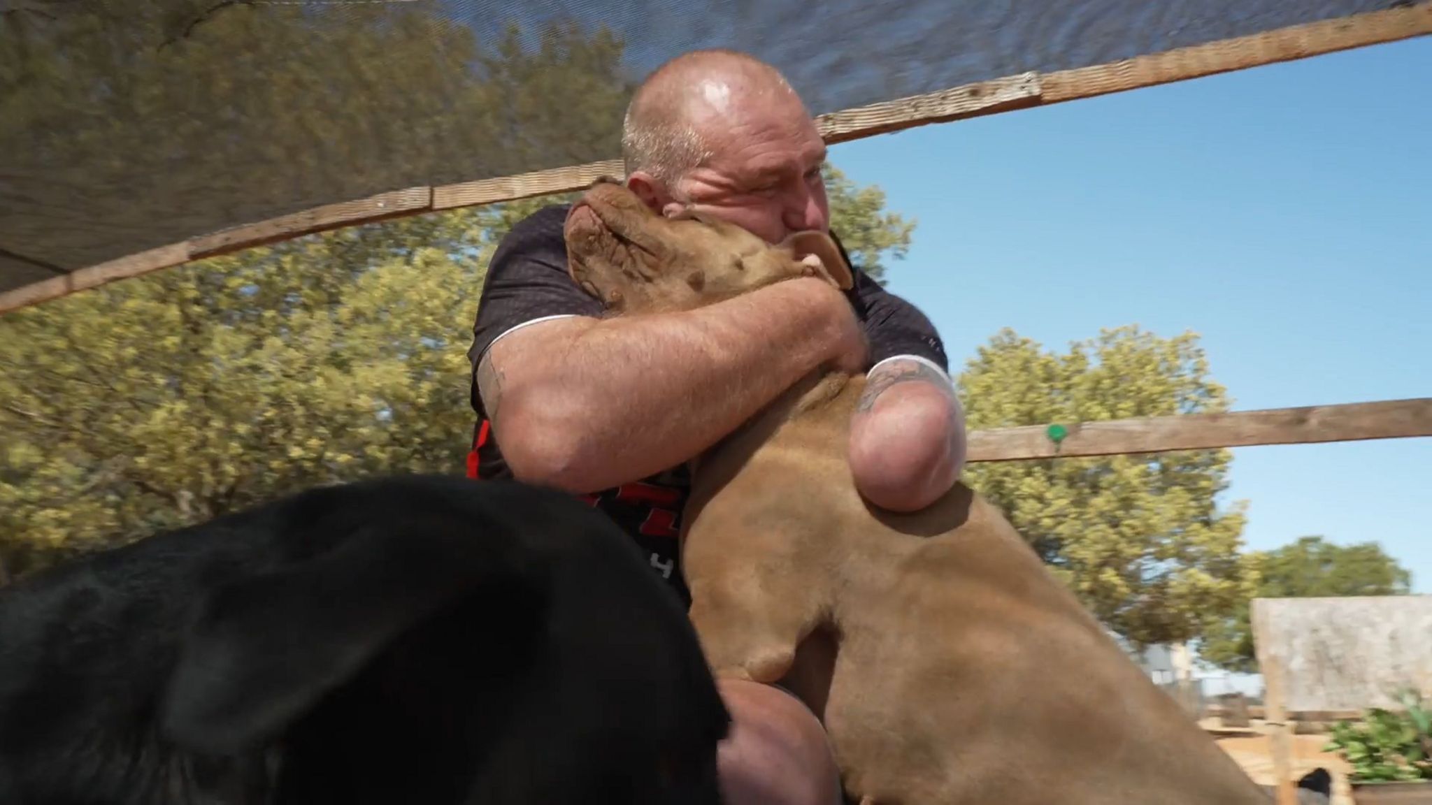 Para archer Shaun Anderson hugs his dog.