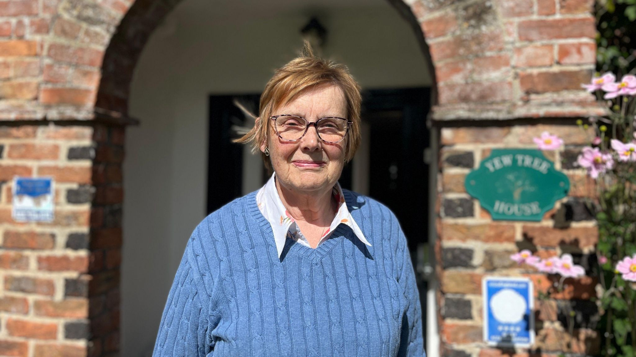 Anne Fox in a blue jumper in front of the entry to her bed and breakfast