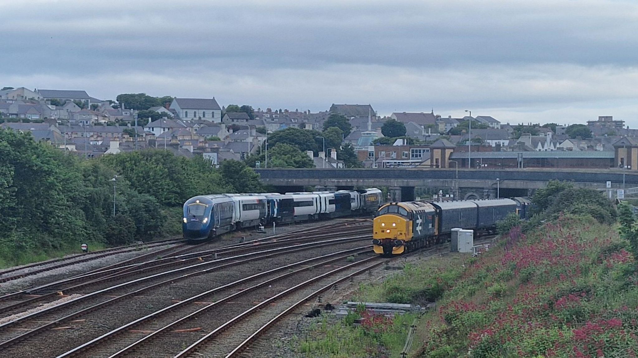 Five track main line at the entrance to Holyhead station with train leaving for Crewe on left and the locomotive from the cancelled train on the right
