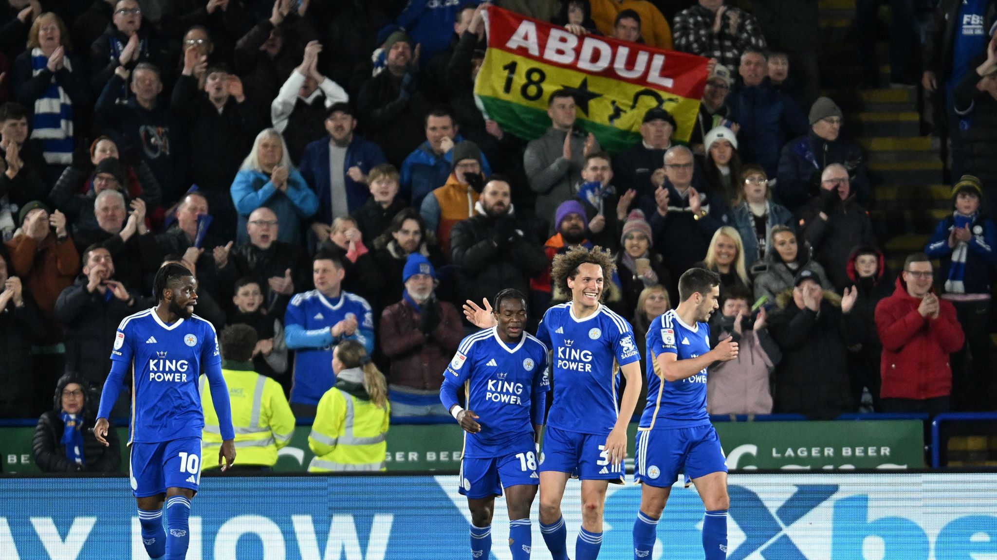 Leicester players celebrate in front of a Ghanaian flag that says "Abdul"