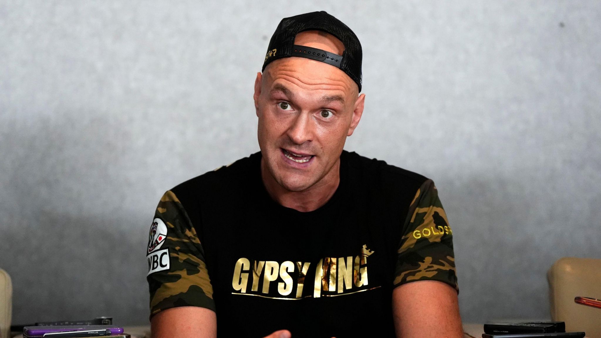 Tyson Fury speaks to the media in a backwards cap