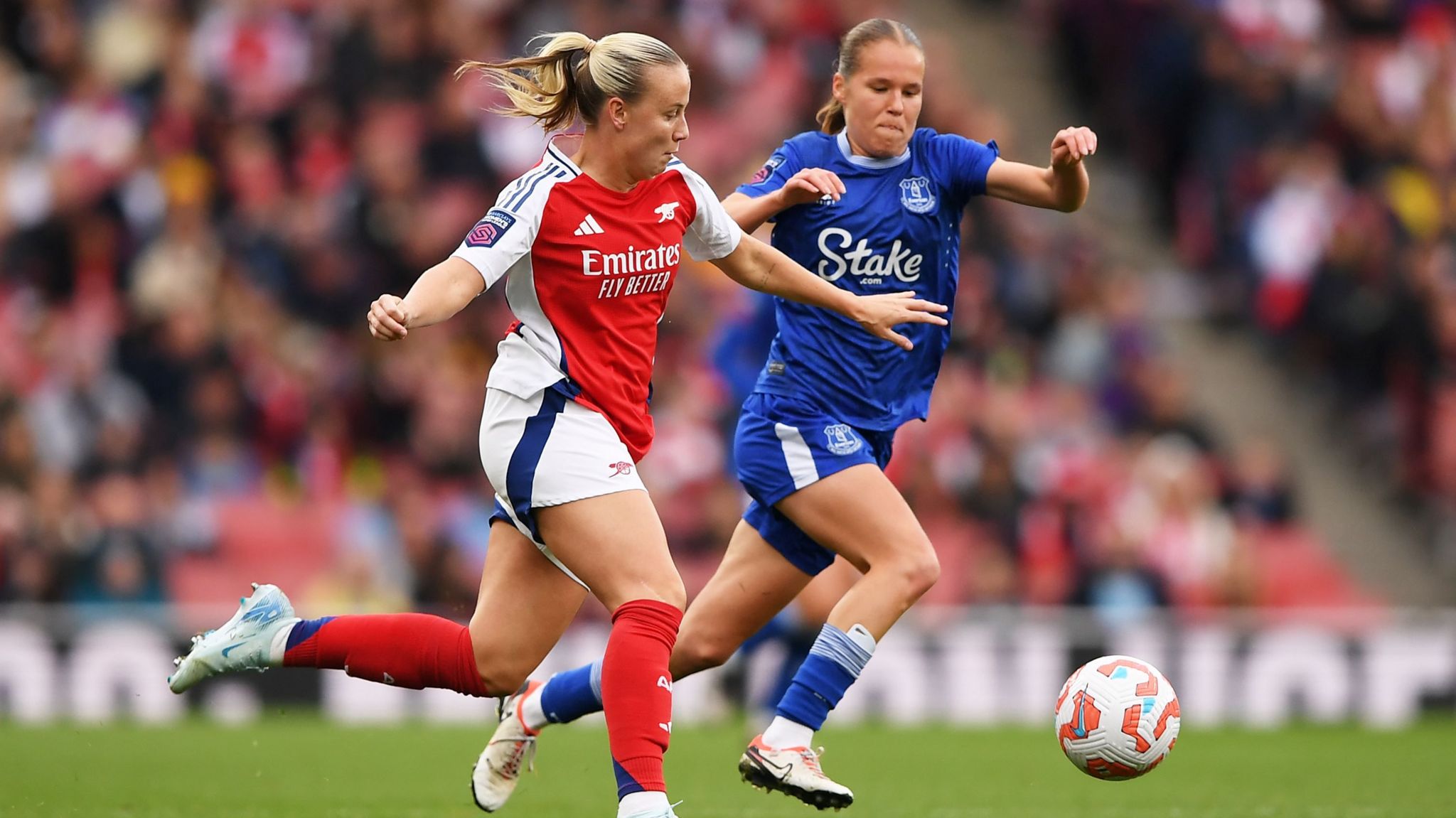 Beth Mead of Arsenal is challenged by Karoline Olesen of Everton