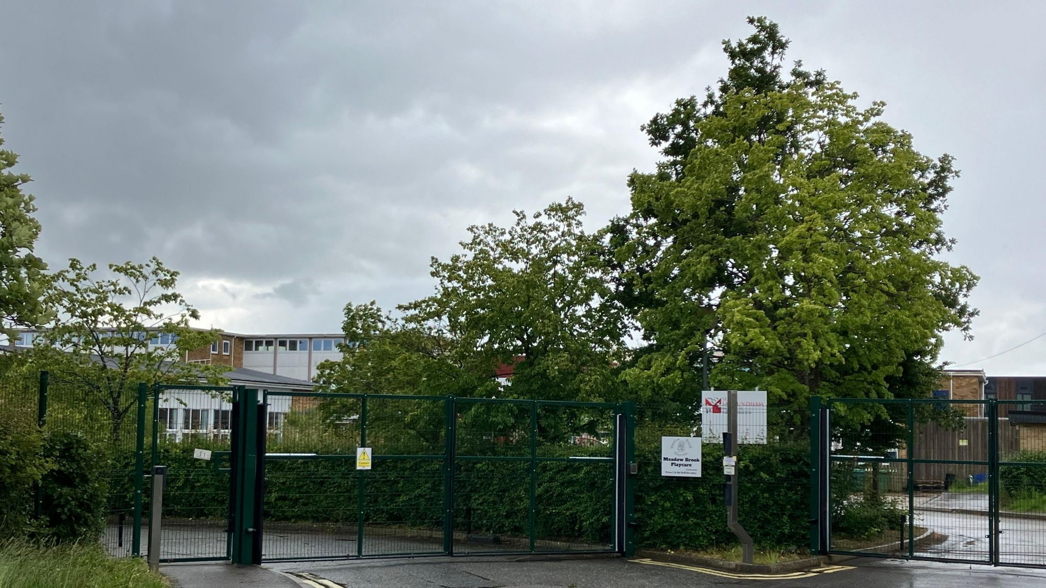 Metal gates and trees at the front of Saxmundham School
