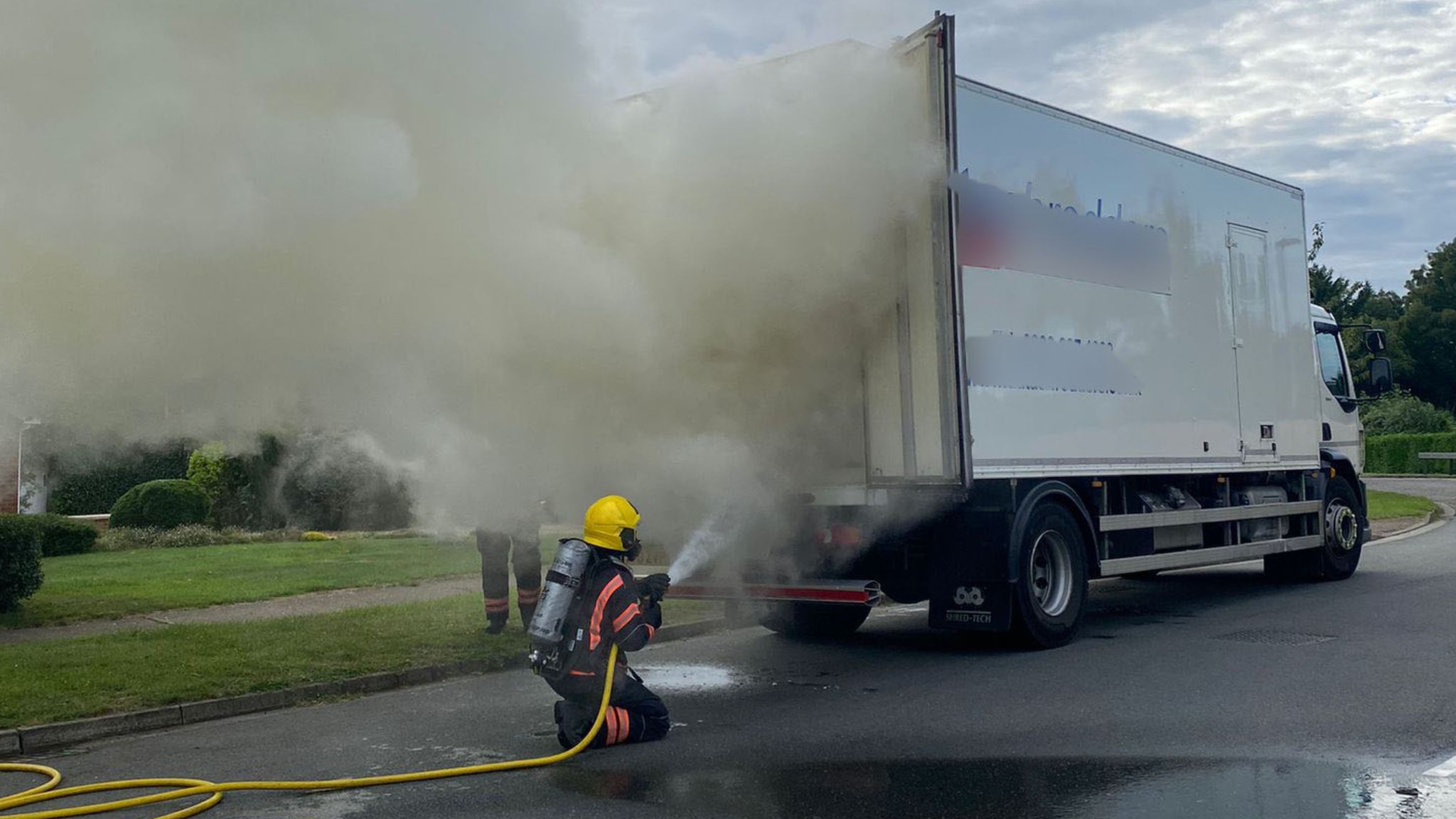 Firefighter dowsing down a lorry