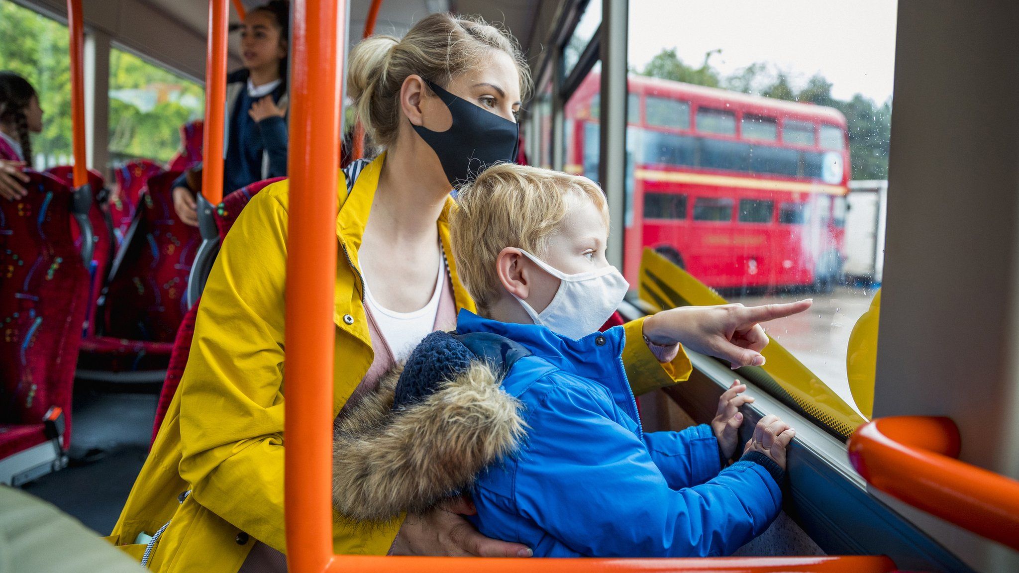 Mother and son on the bus wearing face masks