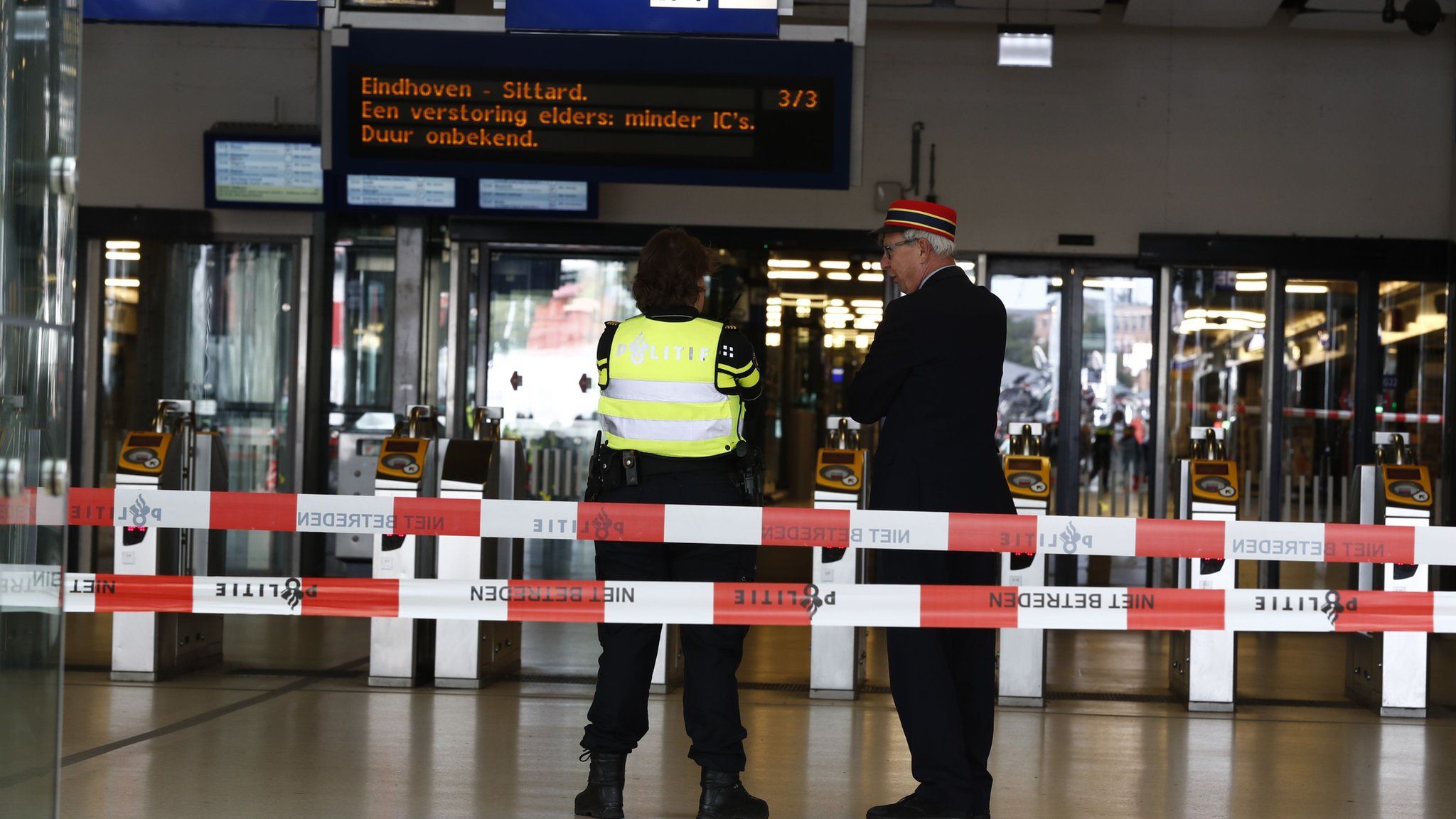Officials stand inside a cordoned-off area at The Central Railway Station in Amsterdam on August 31, 2018,