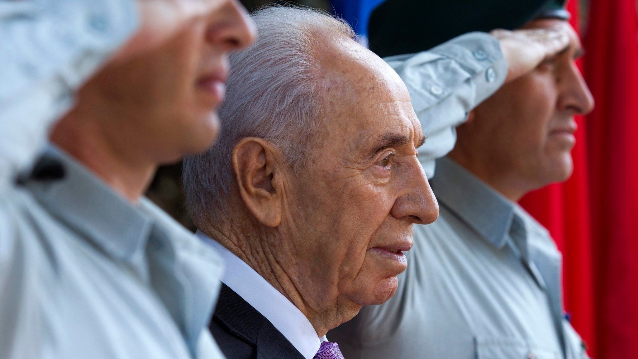 Shimon Peres, flanked by saluting Israeli soldiers, during a ceremony at the president's residence in Jerusalem (17 February 2014)