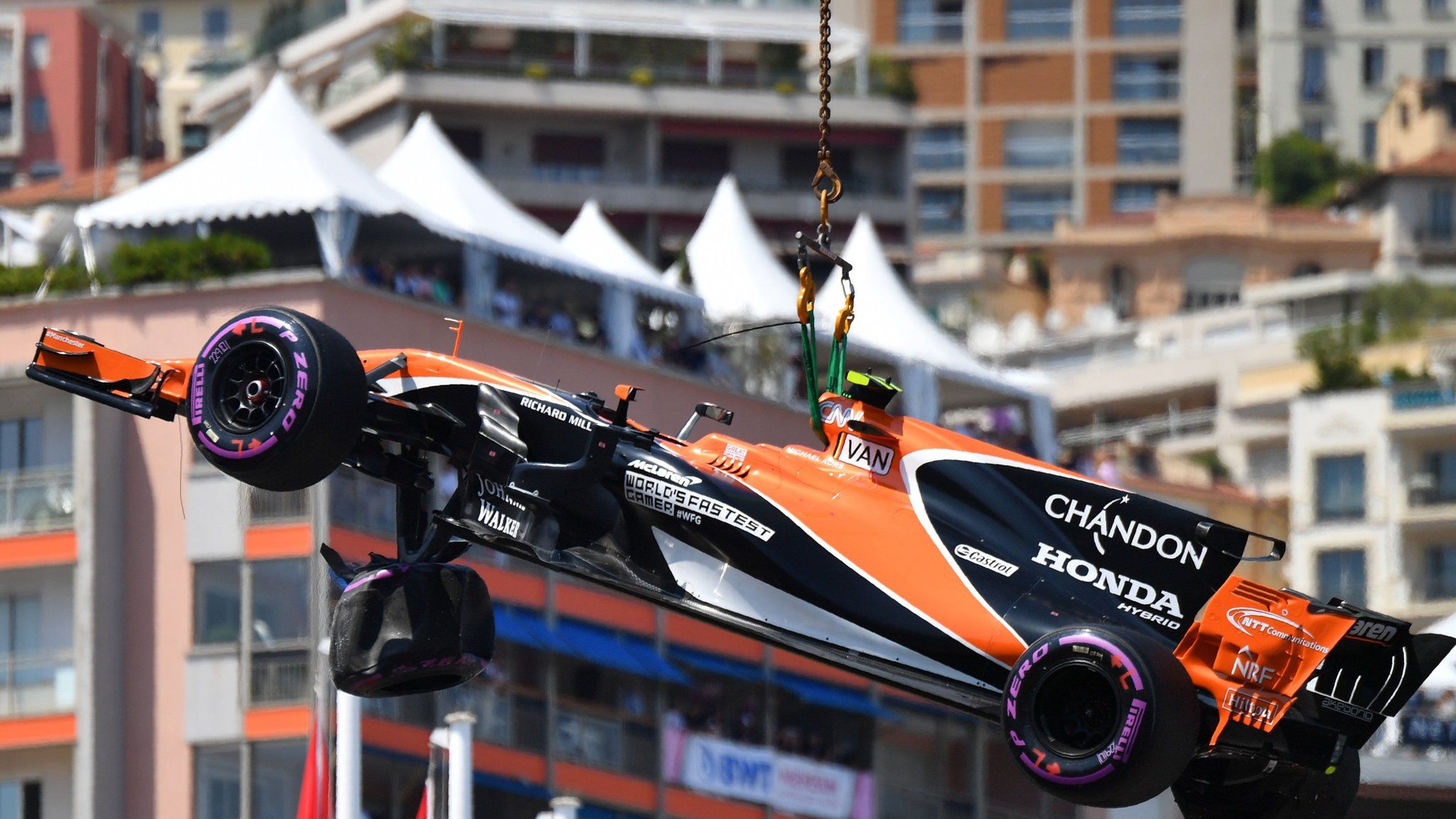 A McLaren car is lifted from the track at Monaco