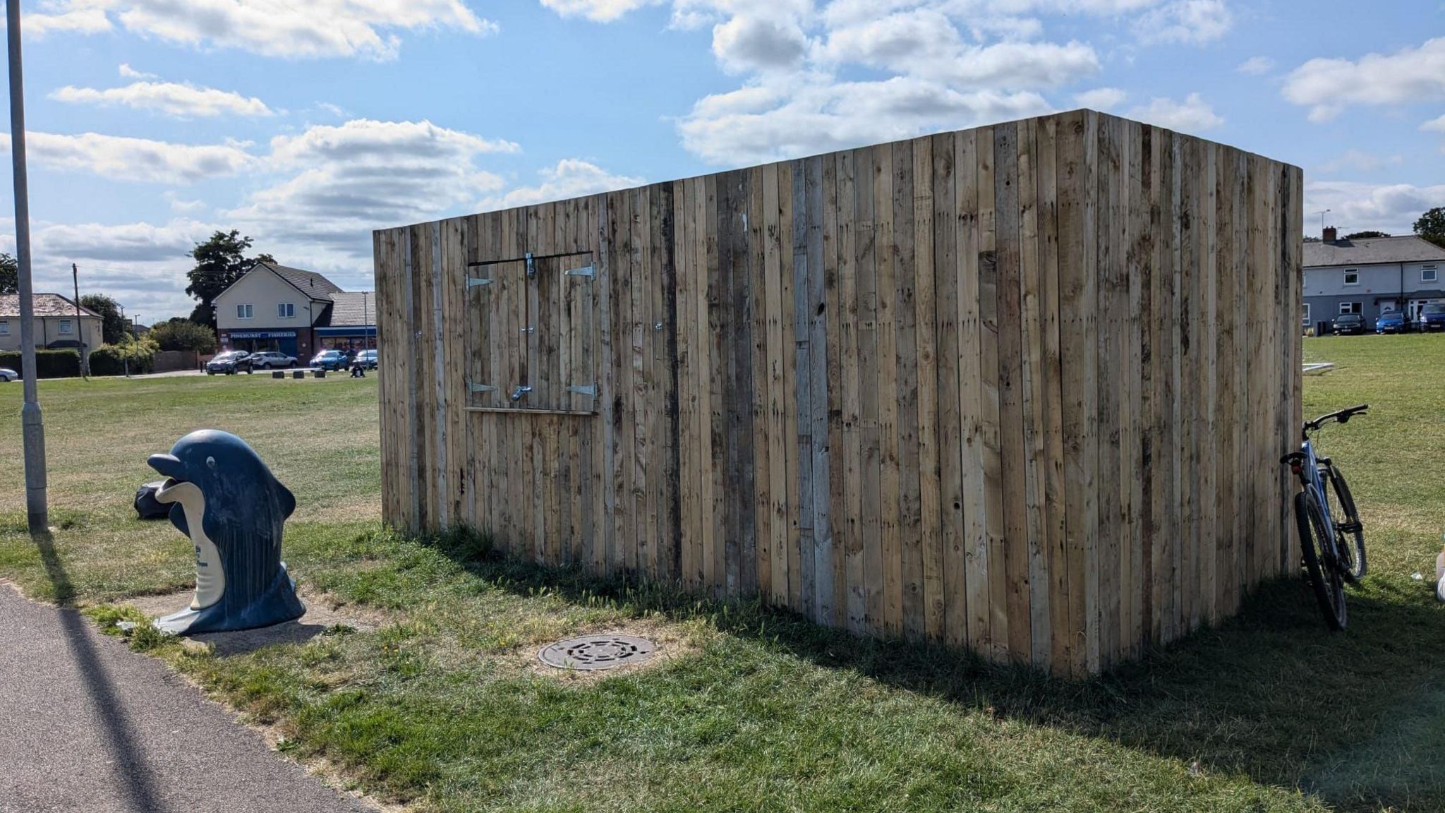 A wooden container and dolphin bin at the Pinetrees Community Centre