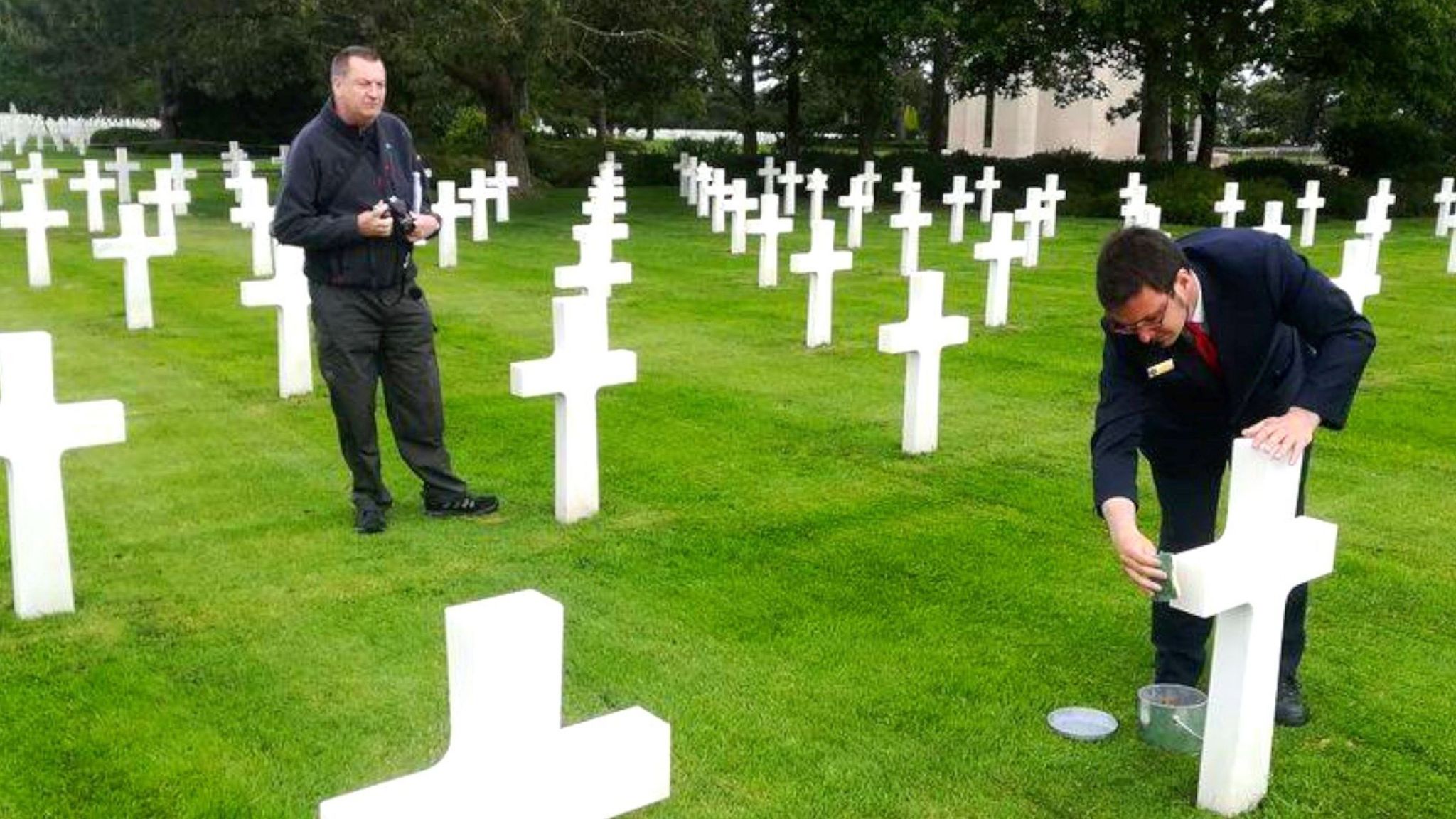 Andy Glenfield watching on as sand from Omaha Beach is put on the grave of Tony Vickery