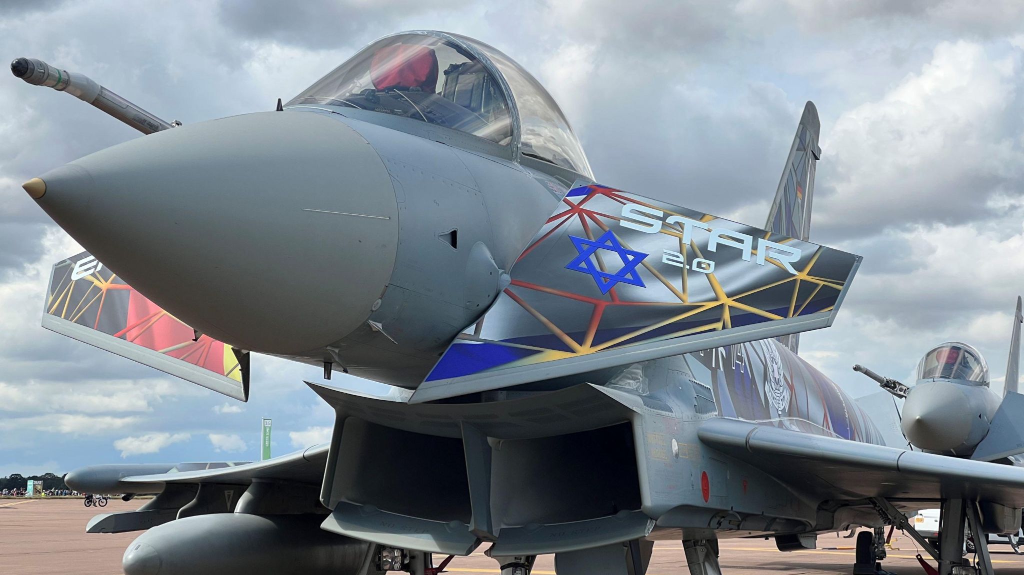 A grey plane with blue and yellow paint on its front wings and the word "star"