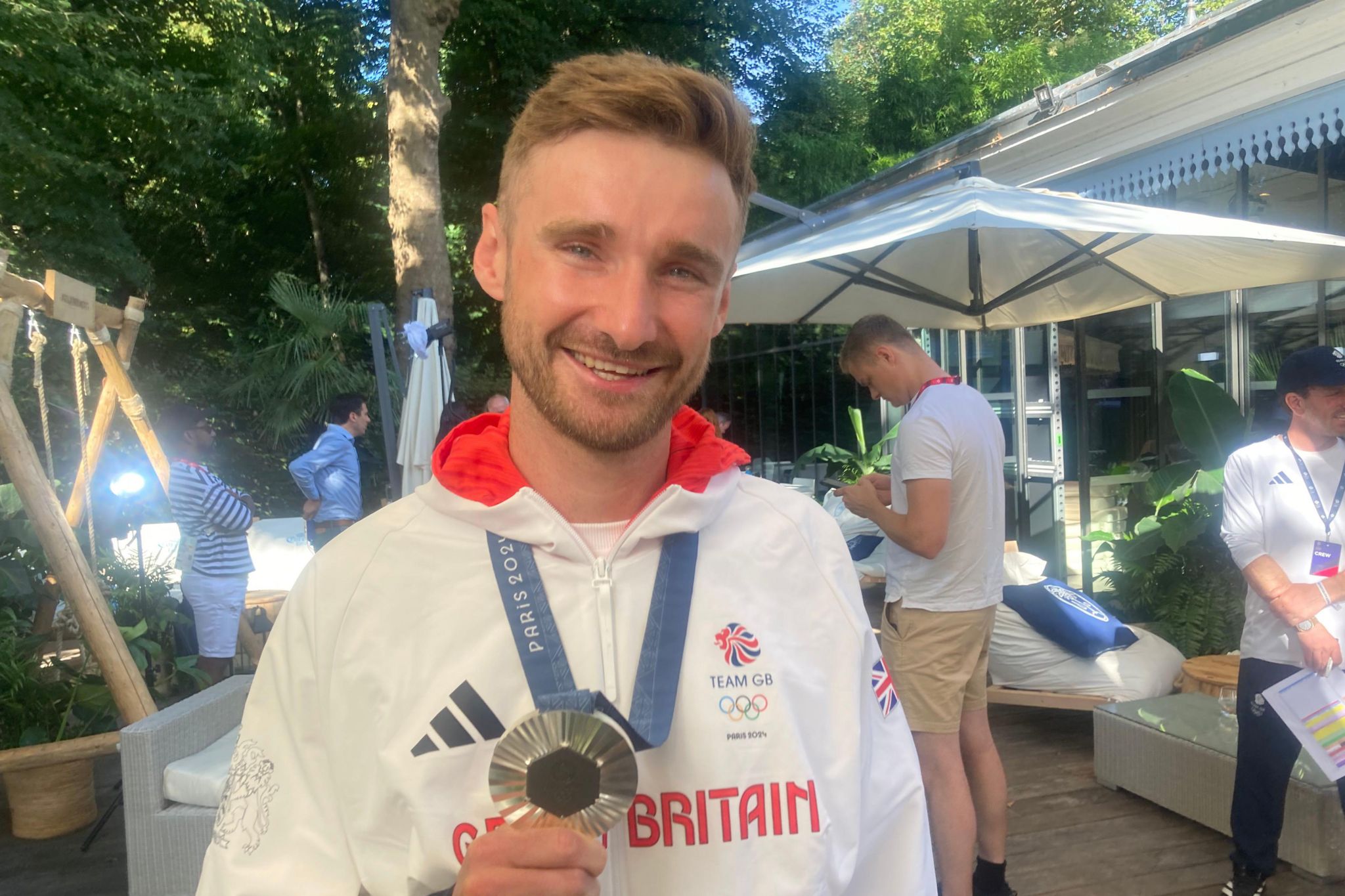 Dan Bigham holding his silver Olympic medal