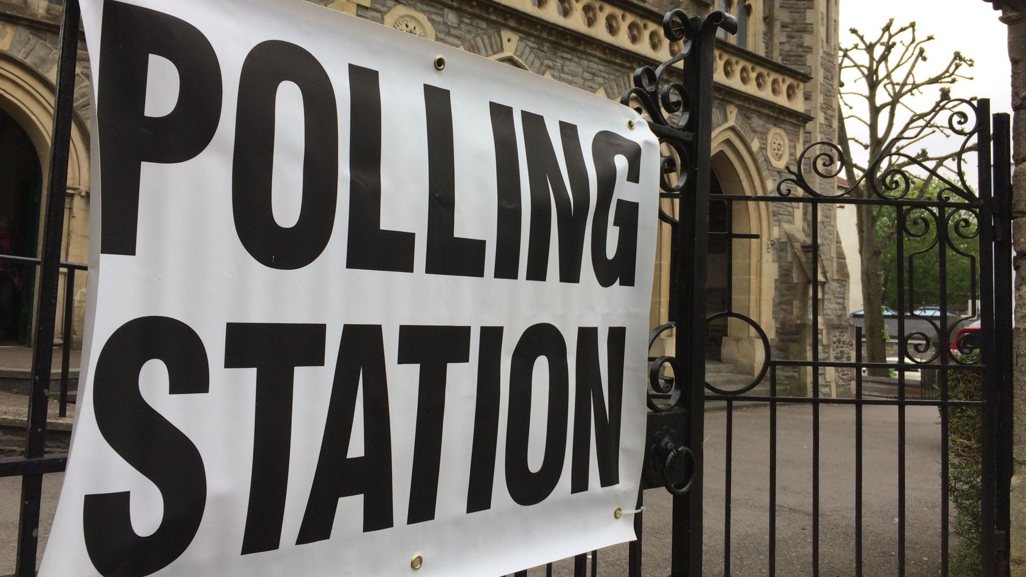 Polling station sign on a fence