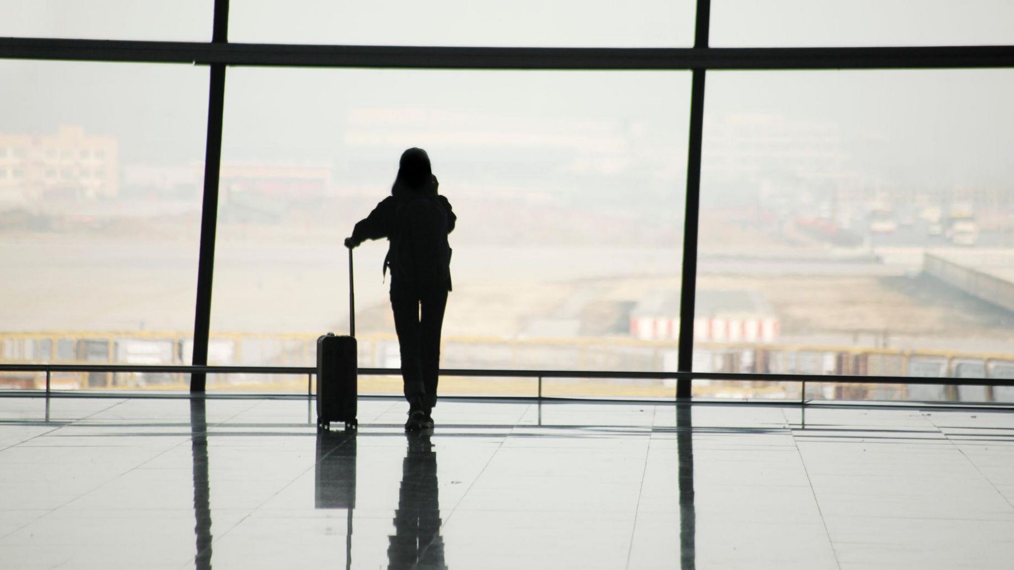 A silhouette of a woman in an airport