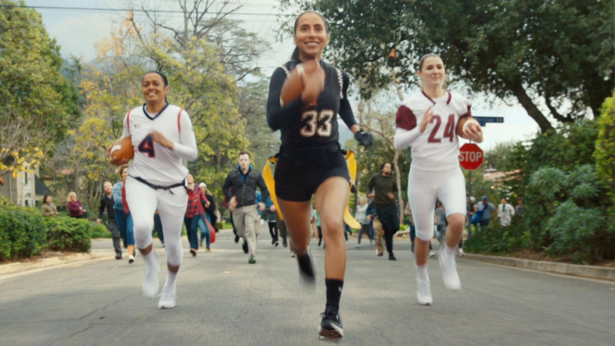 Diana Flores running with a football in a still from a flag football promotion