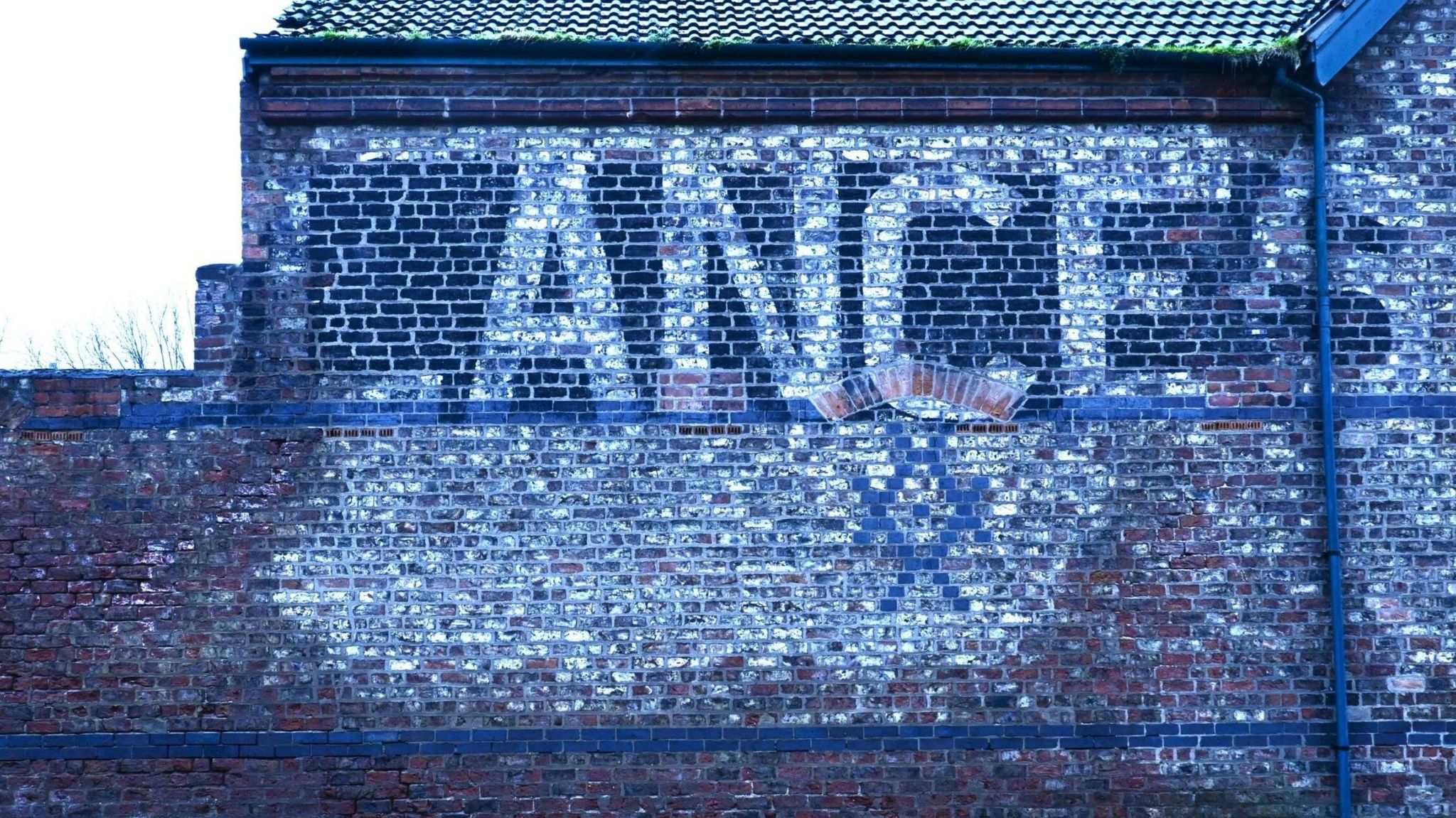 Brick wall that says Lance in white letters