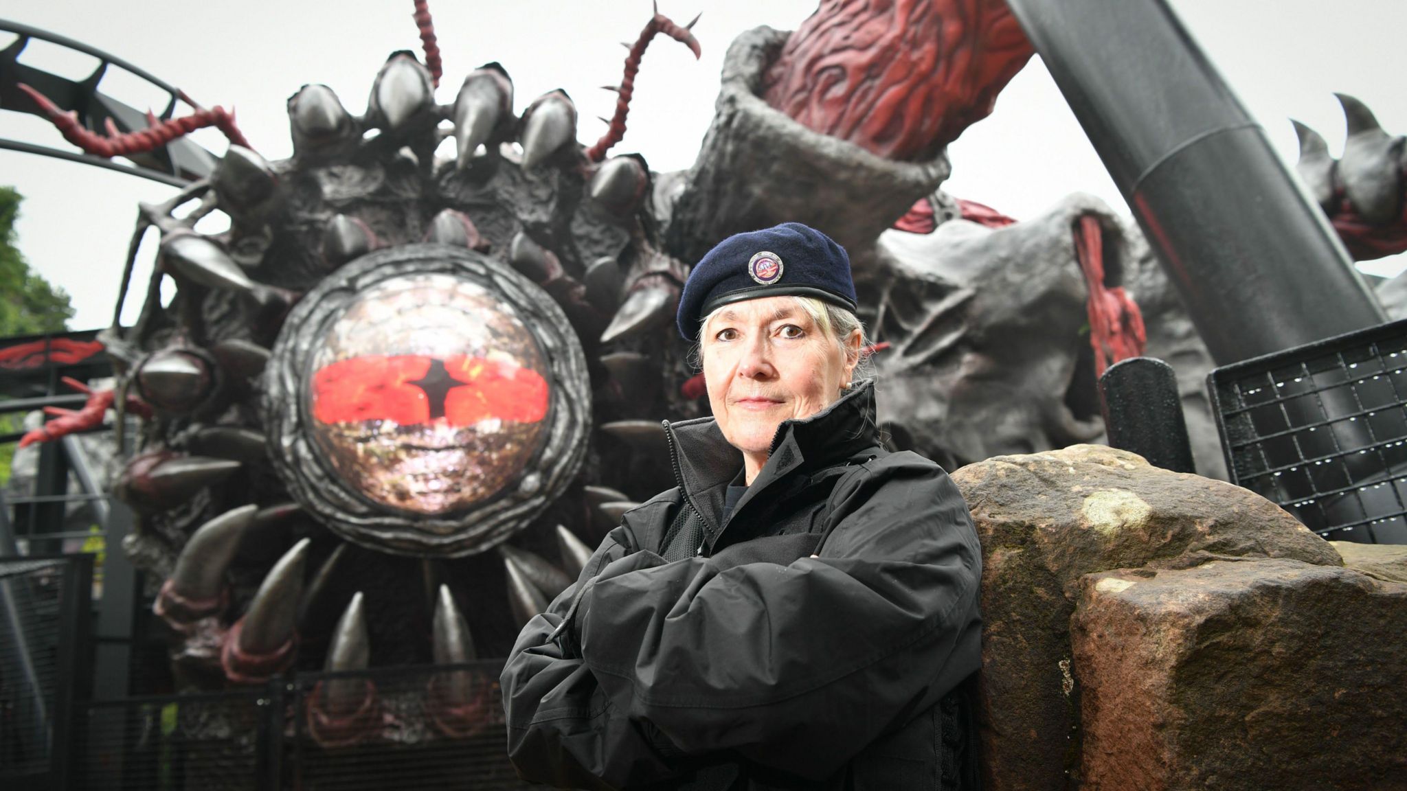 woman standing in front of rollercoaster ride