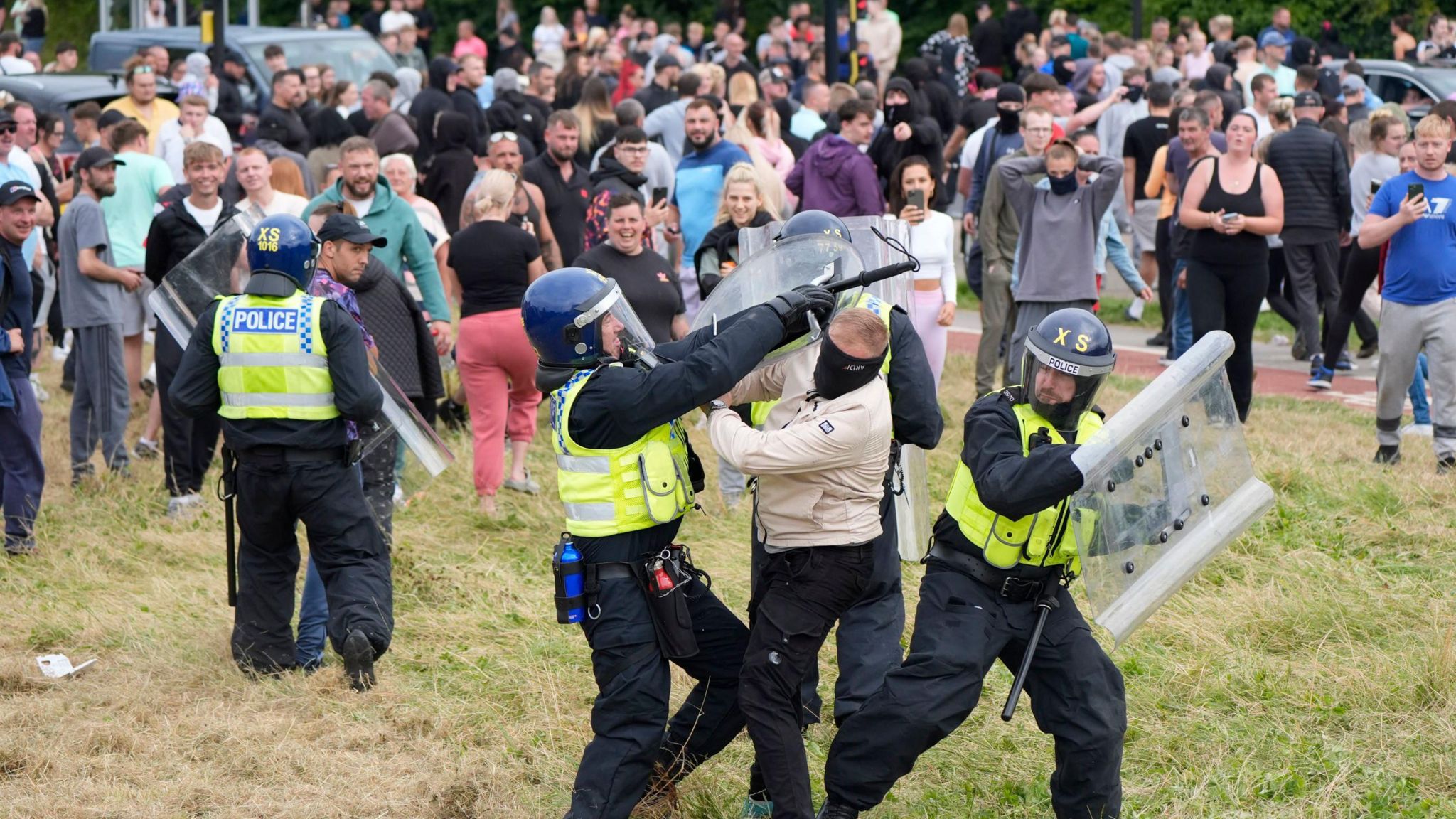 Police grapple with a man as violence erupts at Holiday Inn Express in Rotherham, following a far-right demonstration