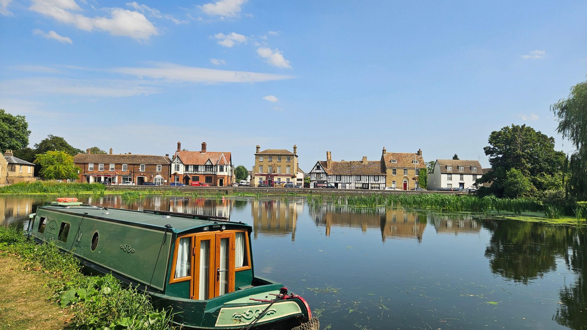 A can boat in a river with Georgian houses on the riverbank
 