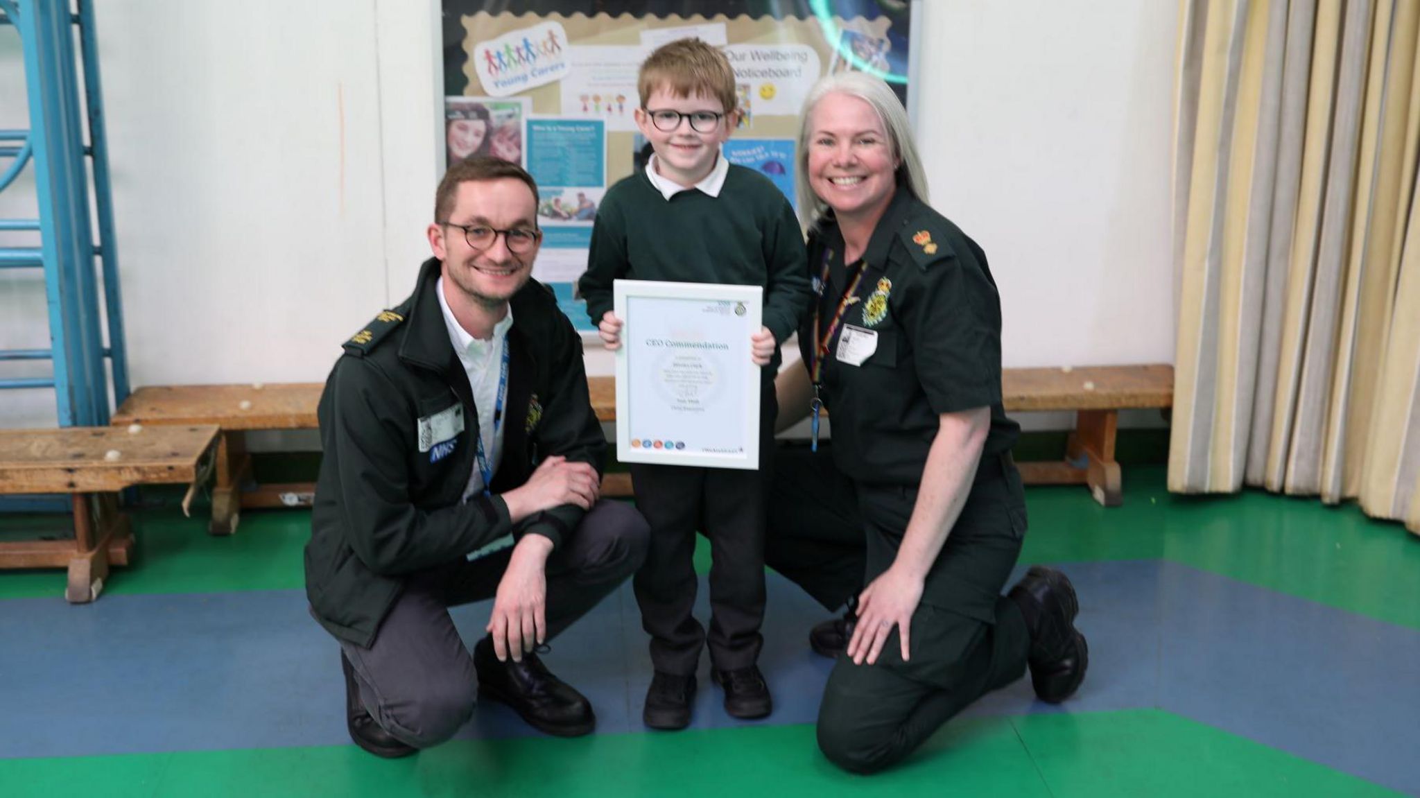 Dimitri Clark holds his certificate with Tom Abell and Michelle Behn either side of him