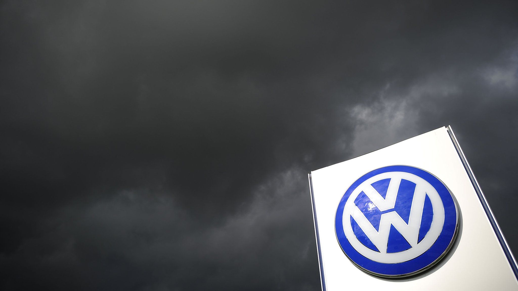 Volkswagen logo under storm clouds