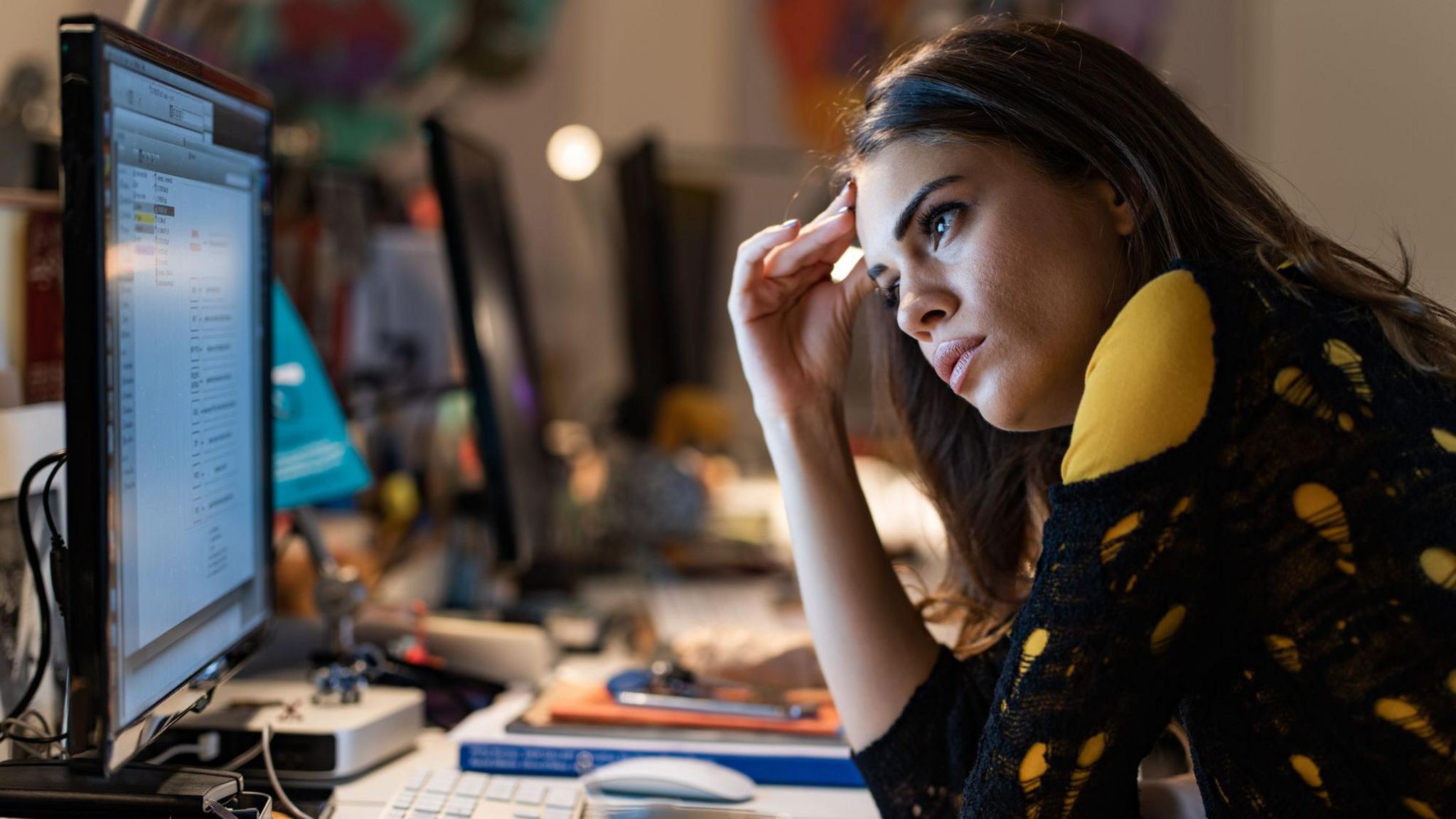 Stock image of a female office worker looking at her PC screen with an exasperated expression