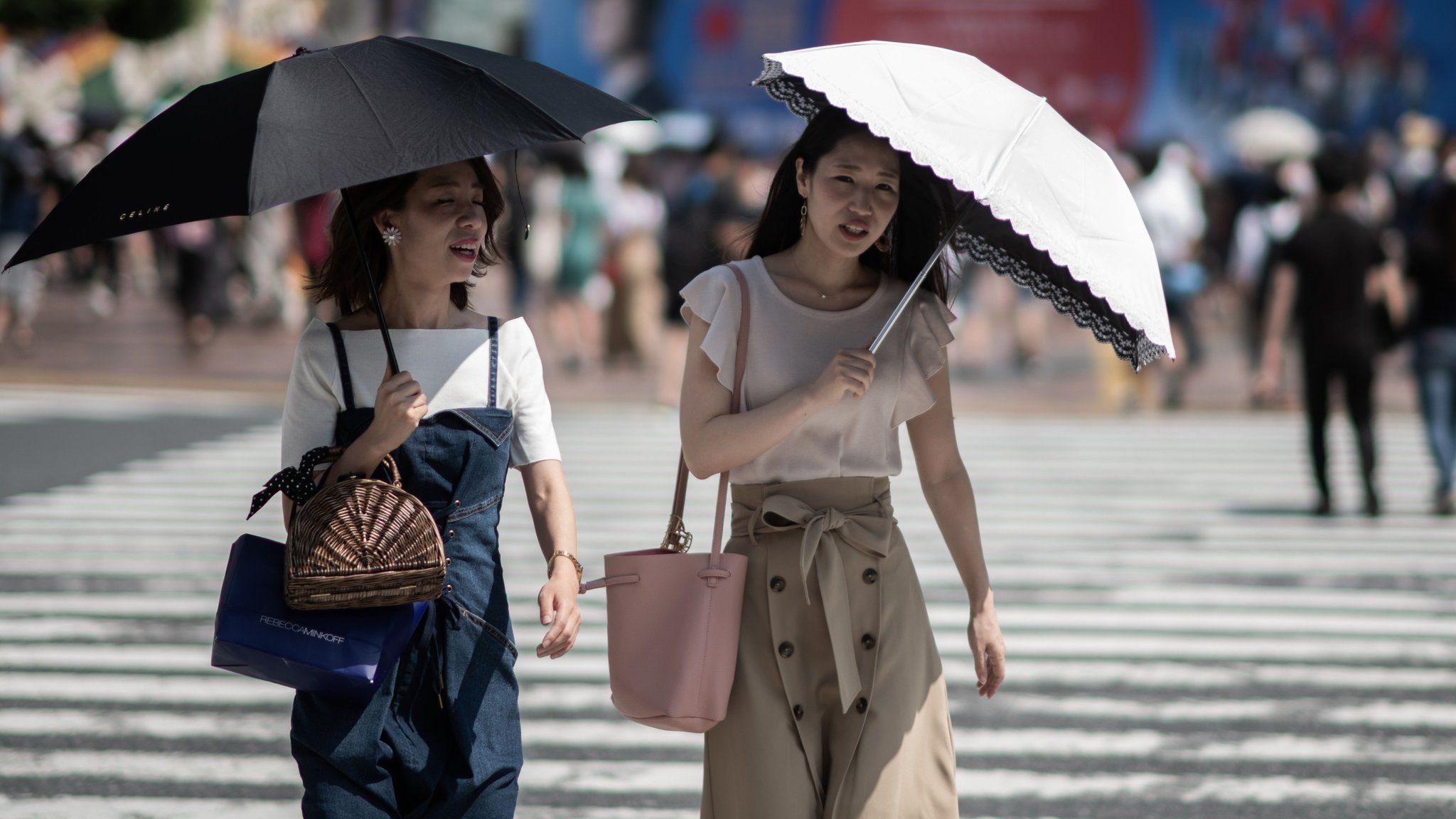 Women shield themselves from the sun with umbrellas in Tokyo on July 24, 2018