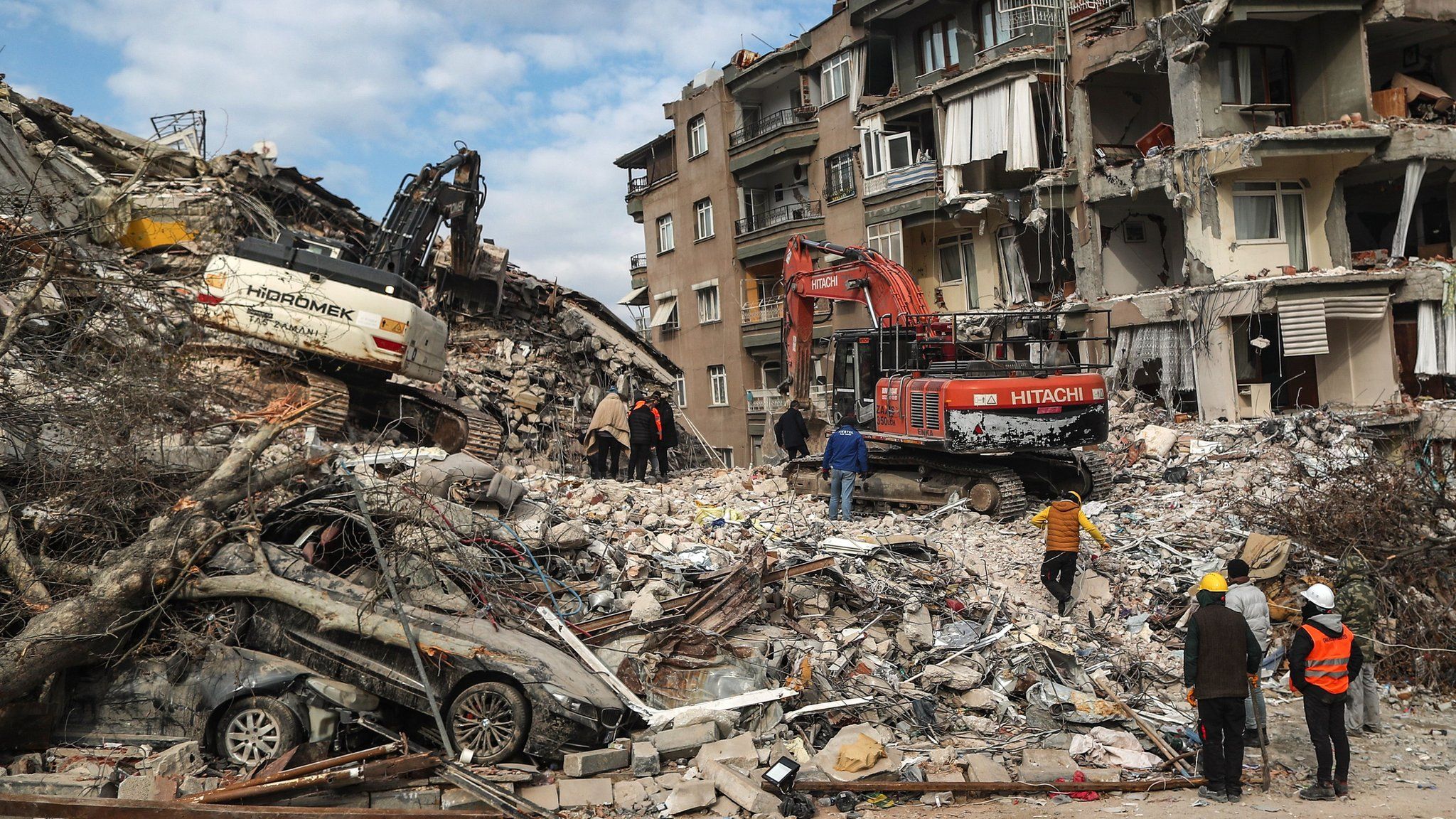 Excavators work on a collapsed building after a powerful earthquake in Hatay, Turkey