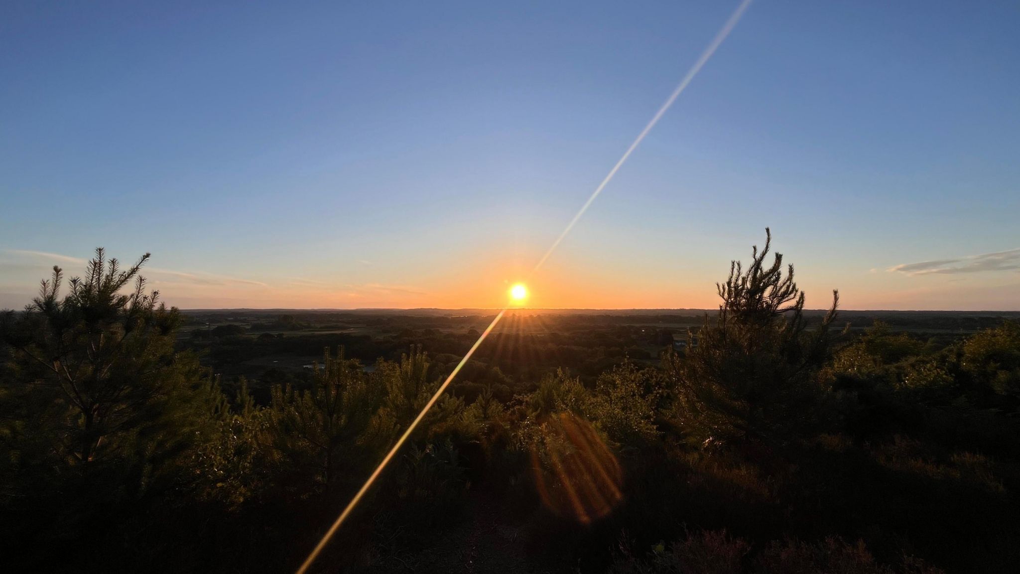 SUNDAY - The sunrises with a lens flare over heathland