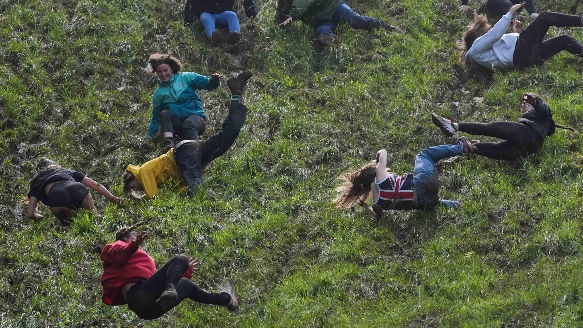 Women tumbling down a hill