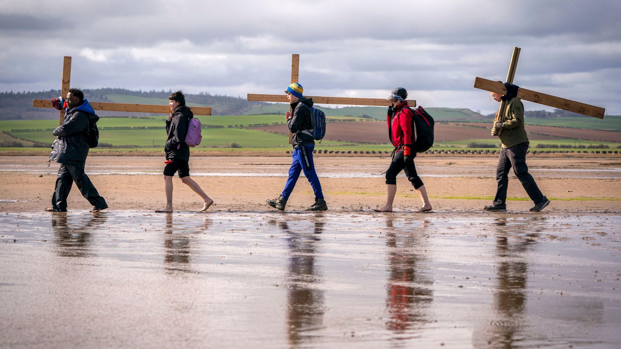 A group of walkers carrying a cross 