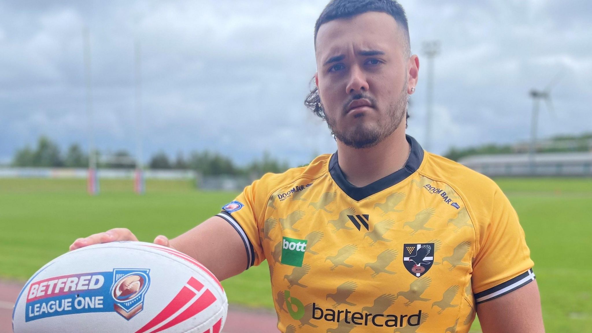 Tomo Clark holds out a rugby ball