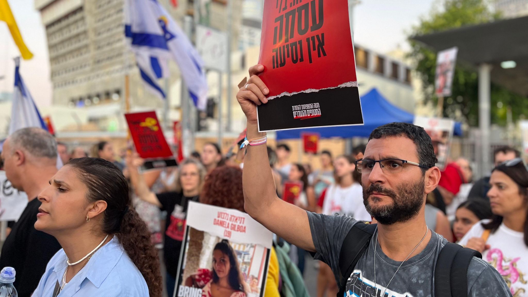 Protesters hold up signs at demonstration for hostages in Tel Aviv on 21 July