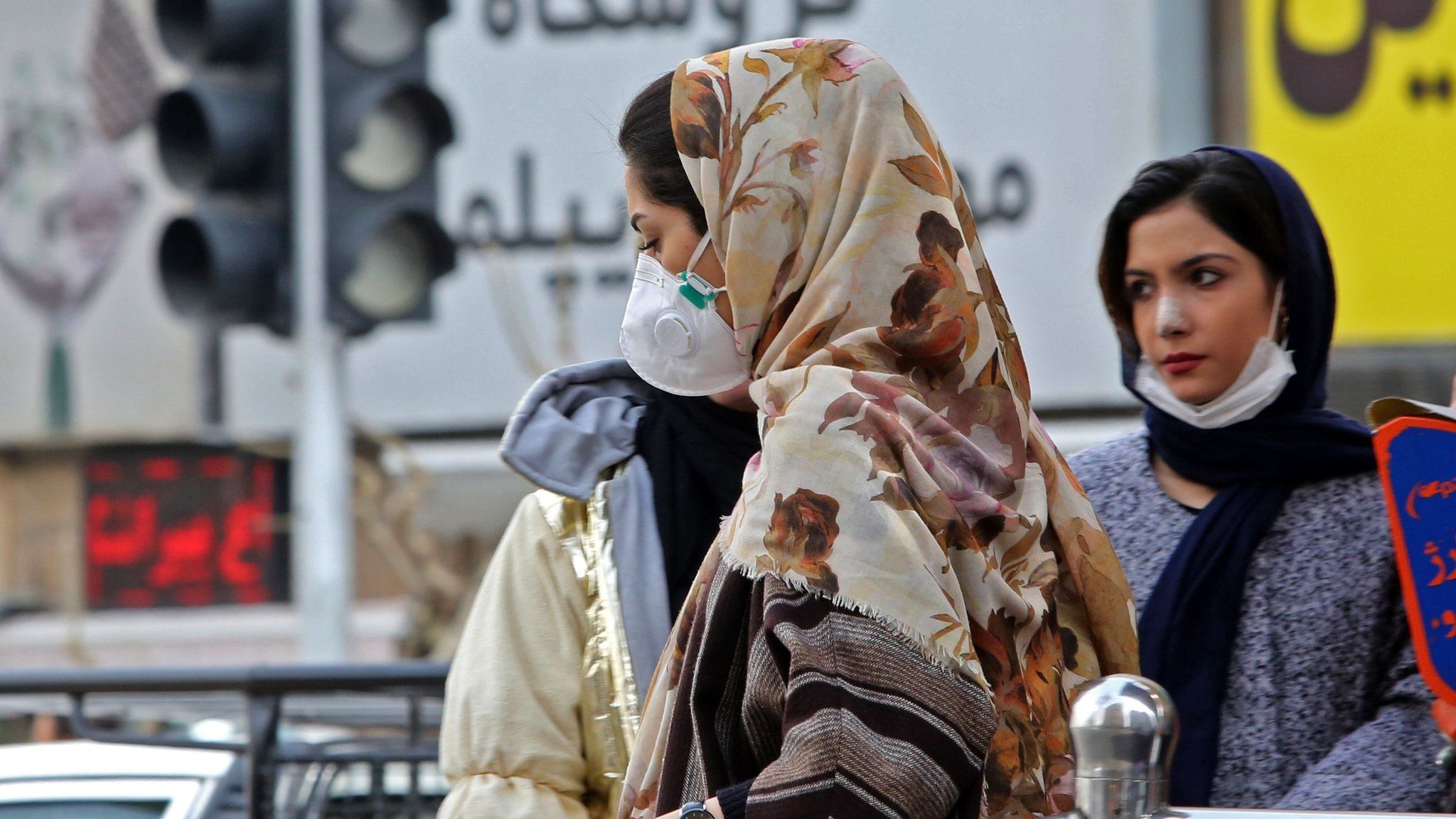 A woman wearing a face mask walks on a street in Tehran, Iran (24 February 2020)