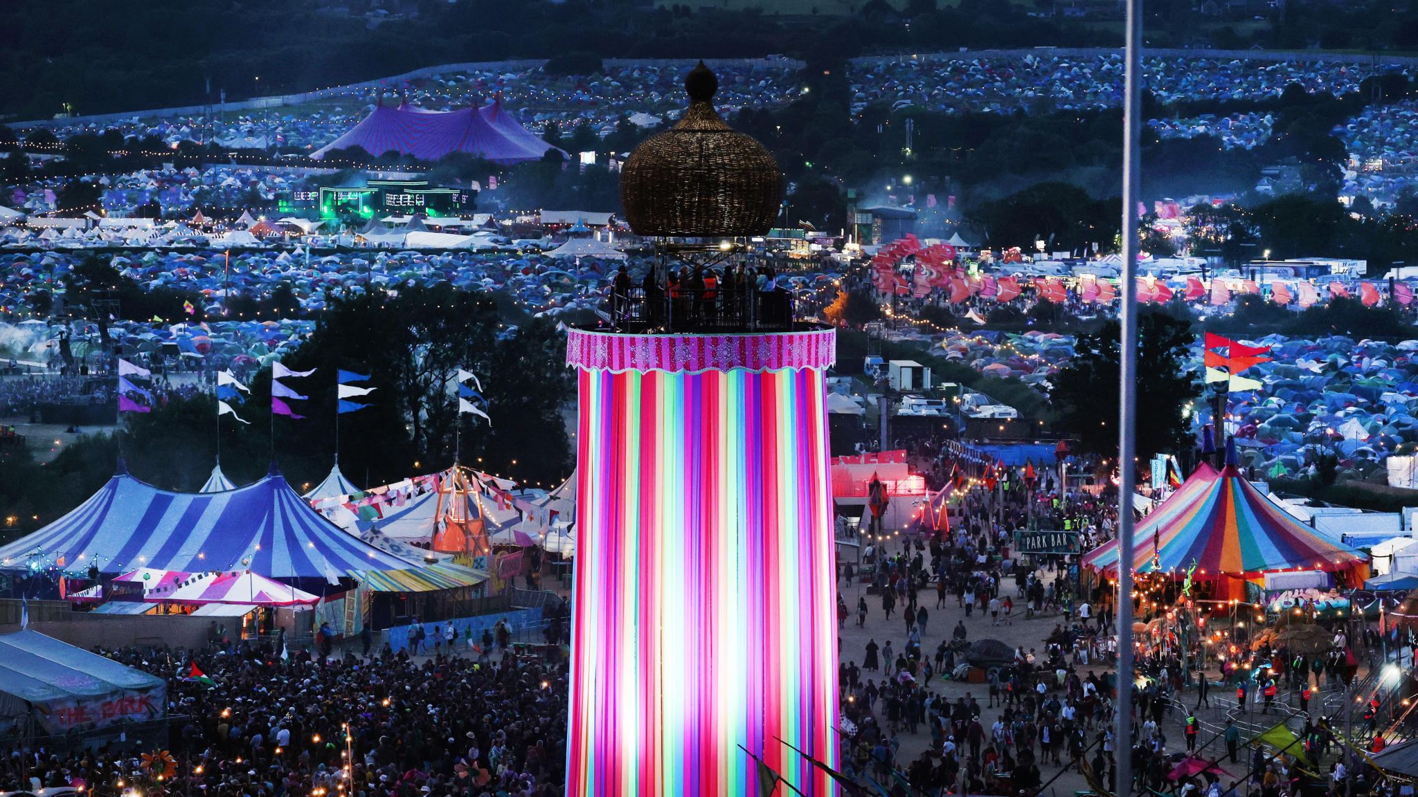 Image of Glastonbury Festival 2024. Tents and crowds of people can be seen. 