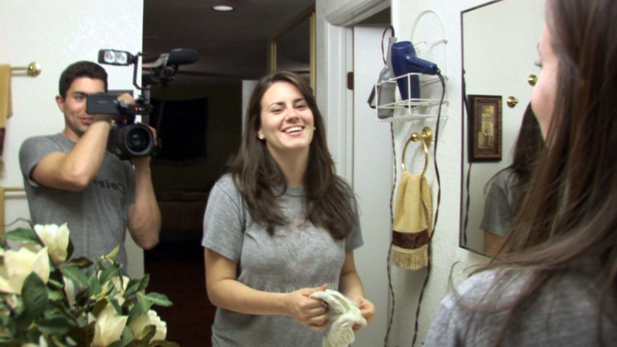 Micah Sloat and Katie Featherston smiling in a still from the Paranormal Activity film