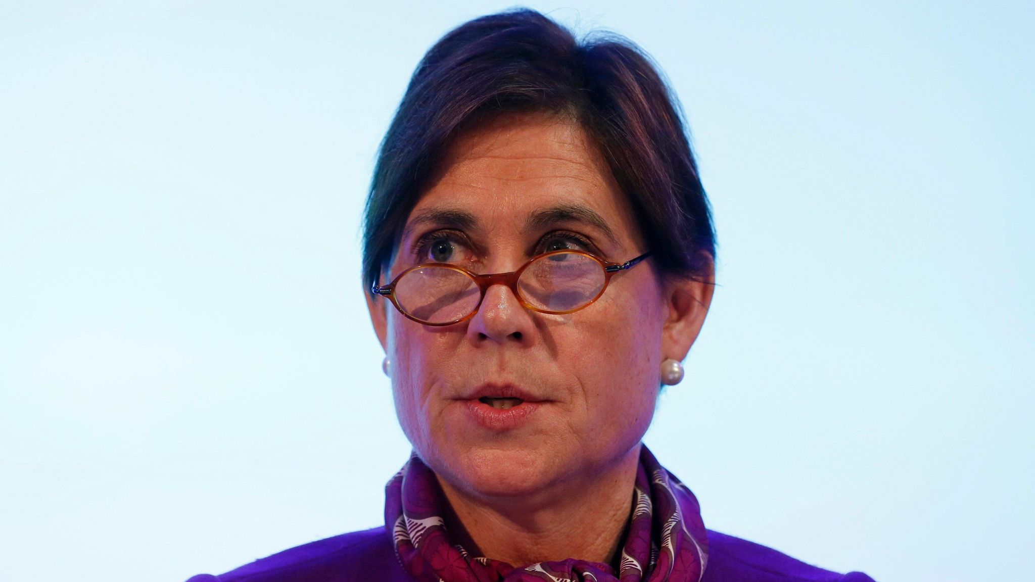 A head shot of Baroness Kate Lampard, peering over the top of small circular-framed glasses and wearing a pashmina 