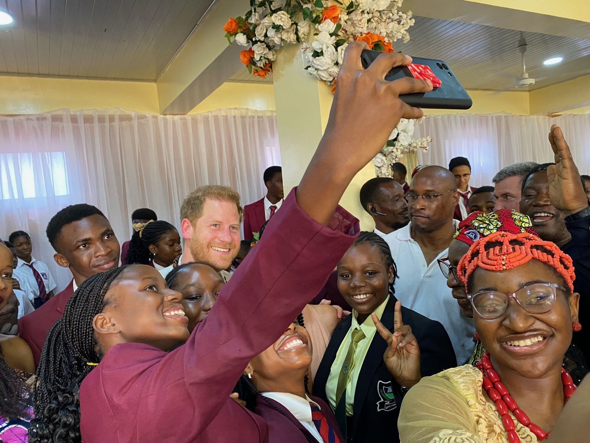 Prince Harry taking a selfie with several students in Abuja